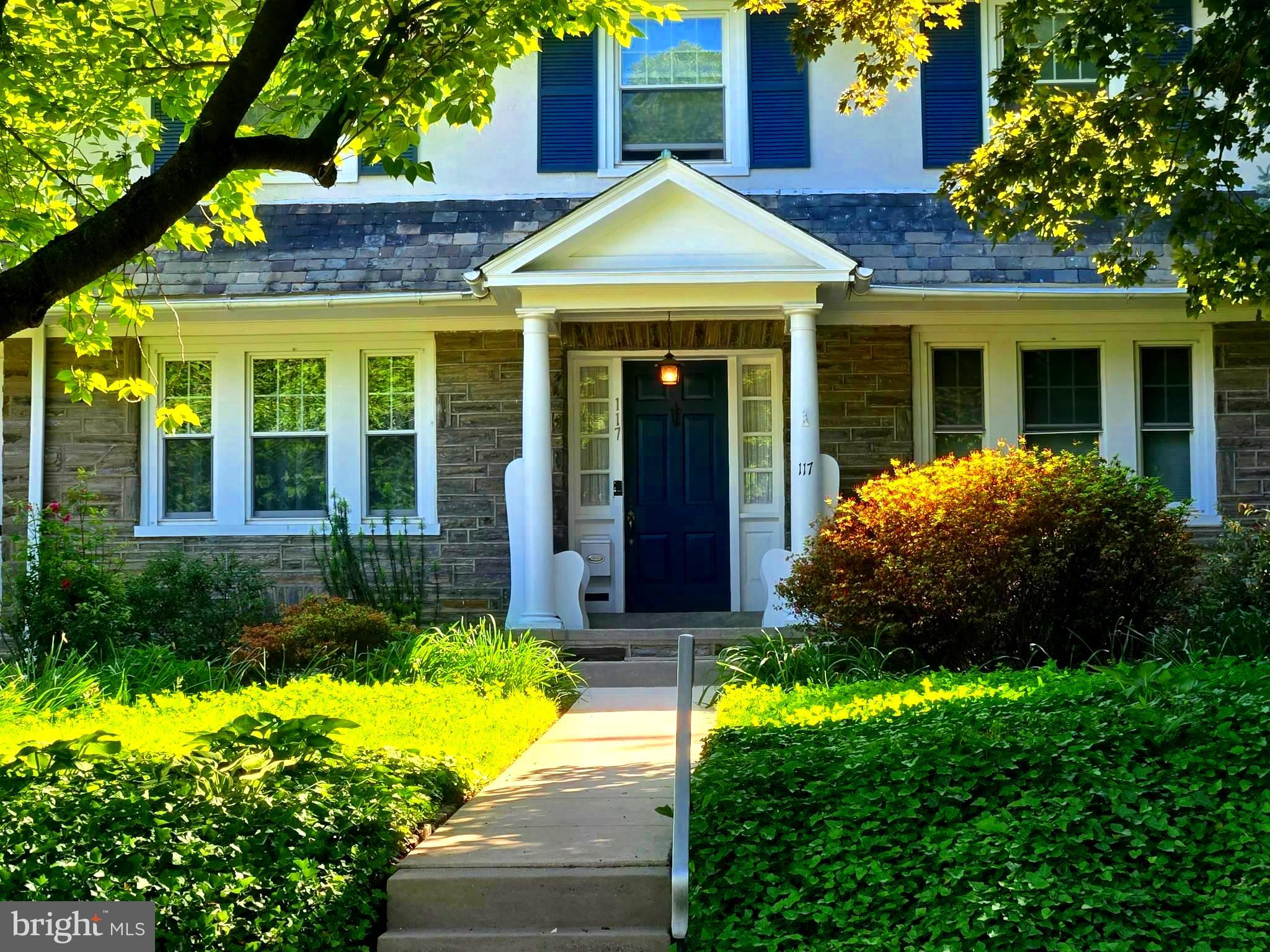 Nestled on a picturesque 1/3-acre lot, this enchanting 1918 Colonial Revival beautifully combines timeless architectural charm with thoughtful modern updates and exceptional versatility. This home is one of the architecturally significant homes featured as part of the Henry Albertson sub-division historic neighborhood. Boasting over 3,363 square feet of living space, this one-of-a-kind home offers 7 spacious bedrooms and 3 full baths, creating endless opportunities for multi-generational living, an in-law suite, income potential, or simply room to grow and entertain in style.
From the moment you step inside, you’ll be welcomed by the warmth and character that only a historic home can offer. Original details blend seamlessly with updated kitchens and baths designed for today’s lifestyle. The flexible first-floor layout features a stunning newly renovated kitchen with soft-close cabinetry, gas range, microwave, and a convenient counter bar that opens to a sunny breakfast room with desk area— the perfect spot to enjoy your morning coffee while conducting your computer communications.
The inviting living room, complete with a cozy wood-burning fireplace and crown molding, flows effortlessly to a bright screened-in porch through elegant French doors, offering the ideal place to relax and unwind, cool off during the summer months, read a book, or dine with family and friends. Interior French doors add to the charm and nostalgia of this home. A formal dining room accented with deep crown molding provides a beautiful setting for holiday gatherings and dinner parties, while the spacious family room just off the kitchen is perfect for entertaining or quiet evenings at home. A generously sized first-floor bedroom and remodeled full bath with a walk-in shower complete the main level.
Upstairs, the second-floor features three generously sized bedrooms with abundant closet space, a private office, and a beautifully renovated full bath. The third-floor private suite offers incredible flexibility with its own full bath, optional second kitchen, and screened porch — ideal for guests, extended family, or a private retreat.
Hardwood floors grace much of the home, with additional hardwood waiting to be uncovered beneath the carpeting. The partially finished basement includes a large workshop, laundry area with folding station, and ample storage space for hobbies and organization. Lots of windows throughout the home bring in light and quiet ambience to every room.
Step outside to enjoy the expansively fenced yard with plenty of room for gardening, play, BBQs, social gatherings, lawn games or simply relaxing and enjoying the outdoors. A utility shed behind the detached 2-car garage with loft for added storage, and private driveway for even more convenience.
Zoned as a triplex, this property offers rare flexibility and outstanding potential for both homeowners and investors. Located in the William Penn School District and just a short walk to shopping and public transportation, this remarkable home offers the perfect blend of space, character, comfort, and opportunity.
Just a short 10-minute walk to the train, a 12-minute commute to University City and hospitals, and a 15-minute ride to Center City makes the need for a car unnecessary.  The airport is accessible by rail and just a 20-minute drive from Lansdowne.  With the home being located just outside the downtown area of the borough, you can walk to the newly renovated Lansdowne Theater for concerts, restaurants, shops, supermarkets, music venues, Farmer’s Market, and some of the 11 parks within the borough. (The historic Lansdowne Sycamore tree is believed to have germinated in the mid-1600’s and is located just a few blocks away in Sycamore Park.) With a vibrant arts community, many organizations within the borough host several indoor and outdoor events throughout the year.  Schedule time to visit this exquisite historically built home.