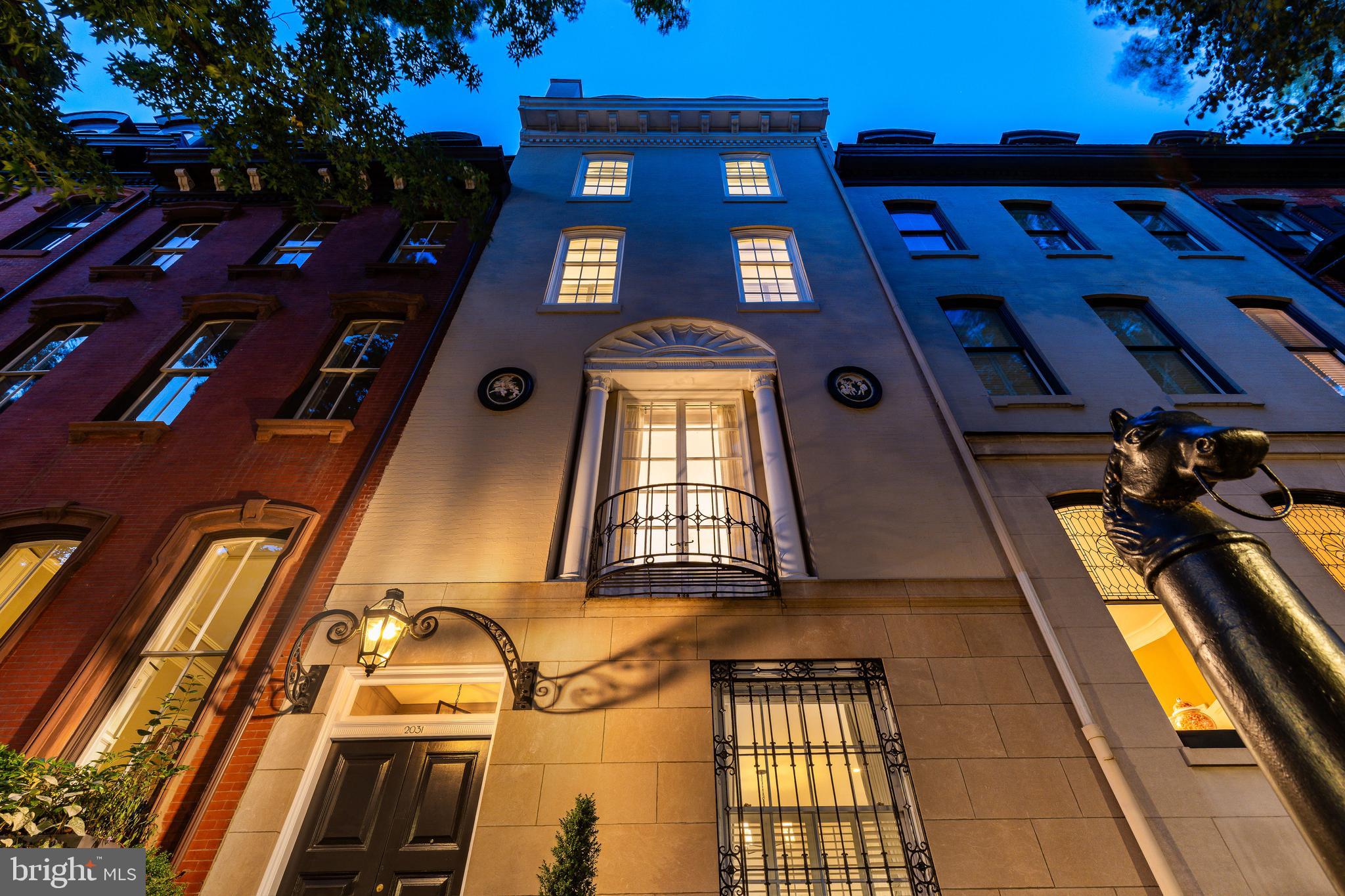 On Delancey’s most storied block, this 6,000+ sq ft, c.1860 mansion—artfully reimagined in 1924 by the celebrated firm Tilden, Register & Pepper—delivers museum-quality craftsmanship and comprehensive modernization. Unlike its brick-clad neighbors, it is one of only two limestone façades on the block, and at six full stories rising approximately 70 feet, it stands as the tallest residence on the street—a landmark of scale, material, and preservation. With 6 beds, 5 full baths, 2 powder rooms, 9 fireplaces, roof deck, a 2-car garage, and an elevator serving all 6 levels from the garden level to the fifth floor, 2031 Delancey stands apart as a meticulously maintained work of architecture and a triumph of engineering—all on a 23 x 93 ft lot. Enter through the original 1860 front door—still fitted with its hand-forged English handle—into a Belgian-marble-paved vestibule. An arched passage frames the sweeping main staircase, which marries the original hand-carved Brazilian mahogany and velvet rail with bespoke Samuel Yellin wrought-iron artistry. Beyond, double doors open to the light-washed living room, wrapped in refined millwork—deep crowns, tall baseboards, and crisp casings. The custom chef’s kitchen features new rift- and quarter-sawn white-oak floor, Brazilian quartzite countertops, a Sub-Zero/Wolf/Miele suite and professionally vented hood. The dining room flows back to the living room, and a service door just beyond the cozy breakfast nook leads to the attached 2-car garage. Ascend to the piano nobile’s Belgian marble landing. To the front, find a formal salon with soaring 12.5’ ceilings crowned by the original 1860 ceiling frieze and a 1909 French chandelier. At rear, the finely crafted library is paneled in American Chestnut, with mahogany floors, an artisan-restored bar, and a hearth of King of Prussia marble. Seamless, historically accurate millwork conceals a powder room and elevator access. French doors lead to the roof deck, with gas and water service, Trex decking, iron railings and views of the skyline. On the third floor, the front primary suite is cocooned and quiet, with 12’ ceilings and new wall-to-wall Berber carpet to soften both acoustics and underfoot feel. Custom built-ins—including a media cabinet pre-wired for television—keep the room tailored and calm. Both suites on this floor feature new walk-in closets and rebuilt ensuite baths in stone and porcelain tile and frameless glass for period-faithful proportion with contemporary performance. New custom shutters and new thermal-insulating, remote-controlled blackout blinds provide privacy on this level and in the two fourth-floor bedroom suites. The rear fourth floor bedroom retains the original pine flooring; the baths echo the home’s holistic renovation. A full-size laundry adds convenience. The elevator opens directly onto the fifth floor, a luminous retreat crowned by a skylight that pours natural light across the original, time-softened pine floors. This level flexes beautifully, with spaces for two bedrooms or a private office and a den, lounge or fitness area. A second kitchen and luxurious full bath make the space self-sufficient for long stays or work-from-home days.   The elevator extends down to the garden level—a finished flex space featuring an iron-gated wine cellar, and a dedicated laundry area.  What truly distinguishes 2031 Delancey is the rigor of its renewal. In recent years, the owners executed a comprehensive systems restoration, including 3-zone HVAC with new furnace and condensers, new heat pump and smart thermostats, Lutron lighting and Sonos throughout,  Double-glazed windows, updated electrical panels, and dual 75-gallon water heaters with booster pumps enhance comfort. At the same time, the home’s legacy materials have been preserved and quietly fortified—each element bringing the home’s 19th-century pedigree forward for your 21st-century lifestyle.