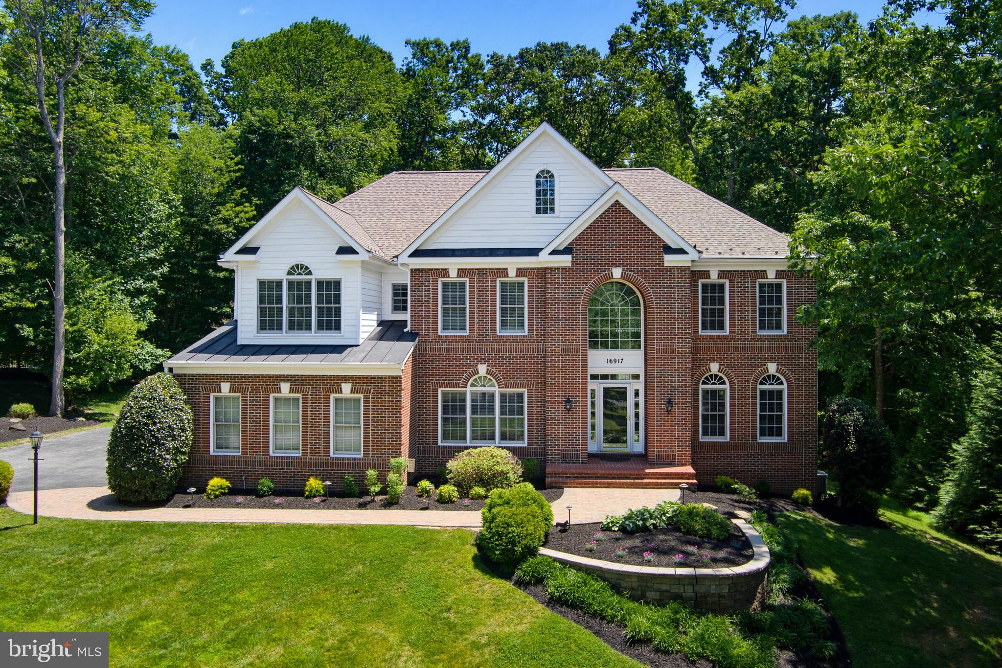Welcome to this exceptional brick-front estate nestled on a private one-acre homesite in one of Howard County's most sought-after communities. Backing to mature trees and protected green space, this beautifully maintained residence offers a thoughtfully designed floor plan that effortlessly balances elegance, comfort, and functionality. A dramatic two-story foyer with an impressive oak and wrought iron staircase sets the tone, welcoming you into a home filled with rich hardwood flooring, soaring ceilings, abundant natural light, and timeless architectural details.

At the heart of the home, the gourmet kitchen is designed for both everyday living and entertaining, featuring cherry cabinetry, granite countertops, updated stainless steel appliances, gas cooking, a large center island, and a spacious breakfast area that flows seamlessly into the sunroom overlooking the picturesque backyard. The adjacent two-story family room is equally impressive, highlighted by a gas fireplace and dramatic walls of windows that frame the surrounding landscape and flood the space with natural light. Perfectly positioned between the kitchen and formal dining room, a well-appointed butler's pantry with a beverage refrigerator enhances both convenience and entertaining. Formal living and dining rooms provide elegant spaces for hosting family and friends, while a main-level bedroom and full bath offer exceptional flexibility for guests, multi-generational living, an au pair suite, or a private home office. Just off the side-entry three-car garage, a custom mudroom with built-in storage creates the perfect everyday drop zone, while the adjacent main-level laundry room adds an extra level of convenience.

Upstairs, the owner's retreat lives like a private wing of the home, featuring a spacious primary suite with two oversized walk-in closets, a luxurious spa-inspired bath, and two separate sitting areas that offer endless possibilities for a home office, reading lounge, fitness space, nursery, dressing room, or additional living area. The secondary bedroom layout is equally impressive, with two generously sized bedrooms connected by a beautifully designed Jack-and-Jill bath, while a third bedroom enjoys the privacy of its own ensuite bath, creating the perfect princess suite or guest retreat.

The fully finished walkout lower level continues to impress with a spacious recreation area, wet bar, additional bedroom and full bath, and a large flex room perfectly suited for a theater room, fitness studio, home office, hobby space, or playroom. Exterior walkout stairs provide convenient access to the backyard and seamlessly connect the lower level to the home's outdoor living spaces.

Step outside and discover your own private retreat, where extensive landscaping, elegant hardscaping, bluestone patios, composite decking, and a stunning screened gazebo create an outdoor setting that is every bit as impressive as the interior. Whether enjoying a quiet morning coffee, hosting gatherings with family and friends, or simply unwinding after a long day, the outdoor spaces offer exceptional privacy and tranquility.

Lovingly maintained and thoughtfully updated throughout the years, the home reflects true pride of ownership. Recent investments include major system updates and improvements, including a newer roof, water pressure tank, hot water heater, and updated stainless steel appliances. These enhancements, combined with numerous other upgrades throughout the home, provide peace of mind and allow the next owners to move in with confidence.

Ideally located near Clarksville, Columbia, Ellicott City, Frederick, shopping, dining, parks, recreation, and major commuter routes, this remarkable property offers the rare combination of luxury, privacy, convenience, and flexibility that today's discerning buyers seek.