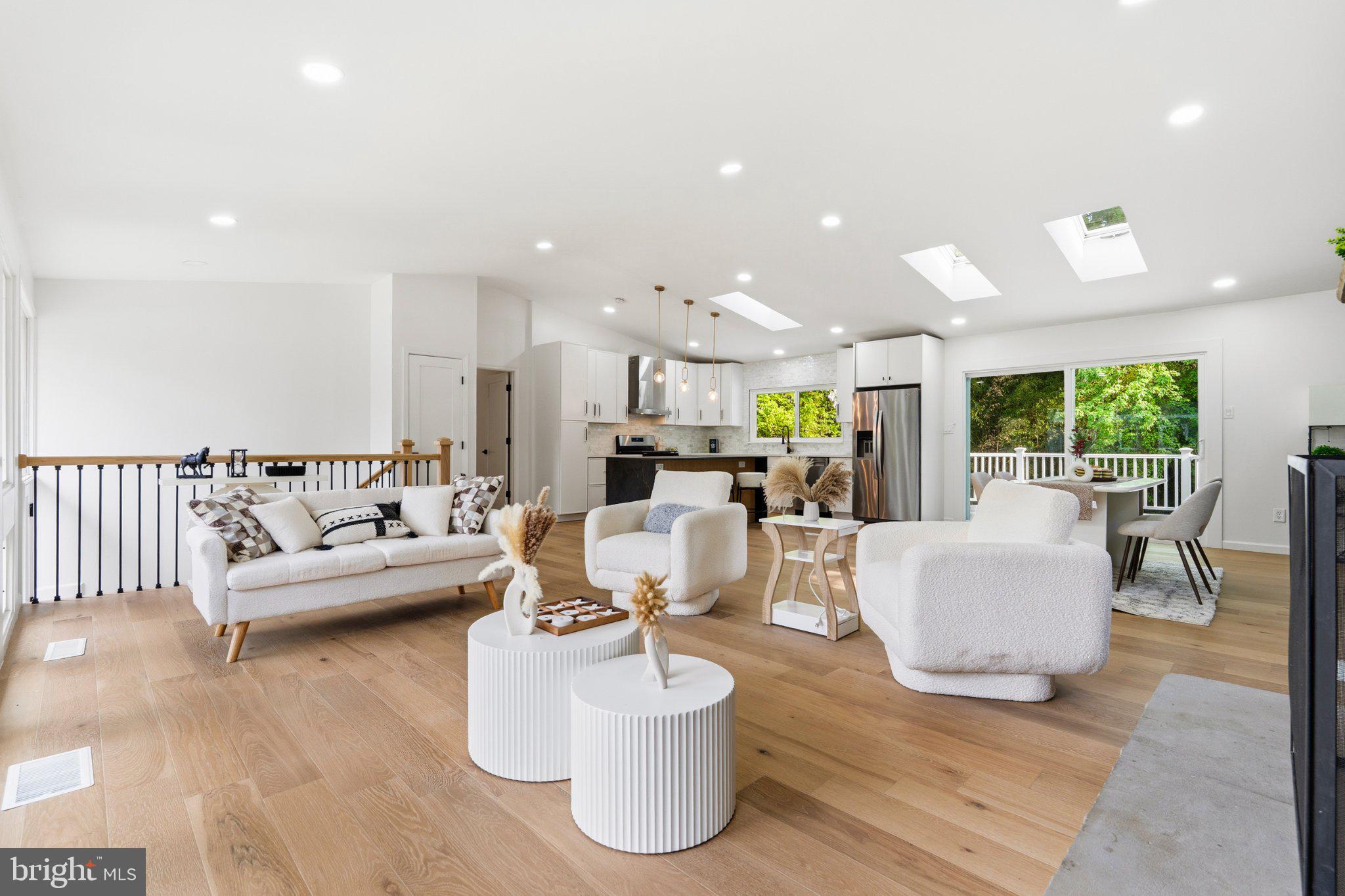Refined. Spacious. Effortlessly Vienna.
Welcome to a beautifully reimagined home where comfort, light, and location come together in perfect balance—just minutes from downtown Vienna, parks, and scenic trails.

Set on a generous 0.35-acre lot, 2800 sqft residence has been renovated from top to bottom in a modern, cohesive style. Featuring a brand-new kitchen, fully renovated bathrooms, fresh paint throughout, and beautiful wood flooring, every detail has been thoughtfully updated.

The main level impresses with soaring vaulted ceilings, skylights, and oversized windows that fill the home with natural light. The kitchen is bright and inviting with a skylight above, while the open-concept living space is anchored by a stunning stone fireplace. This level offers 3 bedrooms and 2 full baths, including a primary suite with private access to the deck and backyard.

Step outside to a huge newly built deck overlooking your own private outdoor retreat—fully fenced, surrounded by mature greenery, and complete with a new firepit area, perfect for entertaining or relaxing evenings.

The lower level expands your living space with a large recreation area featuring a second wood-burning fireplace, abundant natural light, 1 bedroom and 1 full bath, plus flexible space ideal for a home office, gym, or additional living area.

This home offers the perfect blend of indoor and outdoor living, modern updates, and privacy—truly a rare find in Vienna.
Don’t miss it—this is the one you’ve been waiting for.