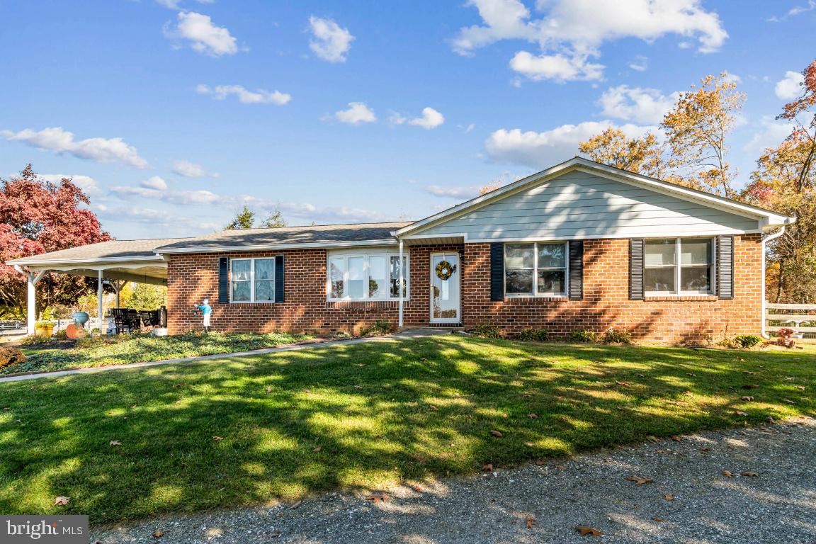 This is an amazing opportunity to own over 7+ acres of pure serenity! This property is surrounded by 3 Board Fencing so bring your horses, chickens, goats and more! The equine setup with a riding arena is a dream! The 3 stall barn has a hay loft, electricity, and a heated tack room with hot and cold water. 
The home has beautiful gleaming hardwood floors throughout, a primary ensuite and 2 generously sized bedrooms. Decorative dental-crown moldings enhance the living room and dining areas. The dining room offers a more formal environment with a chair rail and picture-frame molding. The beamed ceiling and wood-burning fireplace make the family room the place to cozy up on those cold winter nights. The kitchen has tile countertops, an electric cooktop, double wall ovens and SS appliances-it’s warmly inviting you to have family and friends over for a big meal! Start of each day with a cup of Joe enjoying the pastoral views on your front porch or observe nature at its best on your back patio. There’s a huge detached garage with an attached shed for additional storage while the nearby detached building offers concrete flooring and a loft, currently used to store extra hay for the animals. In addition, there are cherry, peach and apple trees producing plenty of delicious fruit to eat fresh, make delectable pies or preserve for winter specialties. The ideal setup for horse owners & private country living!