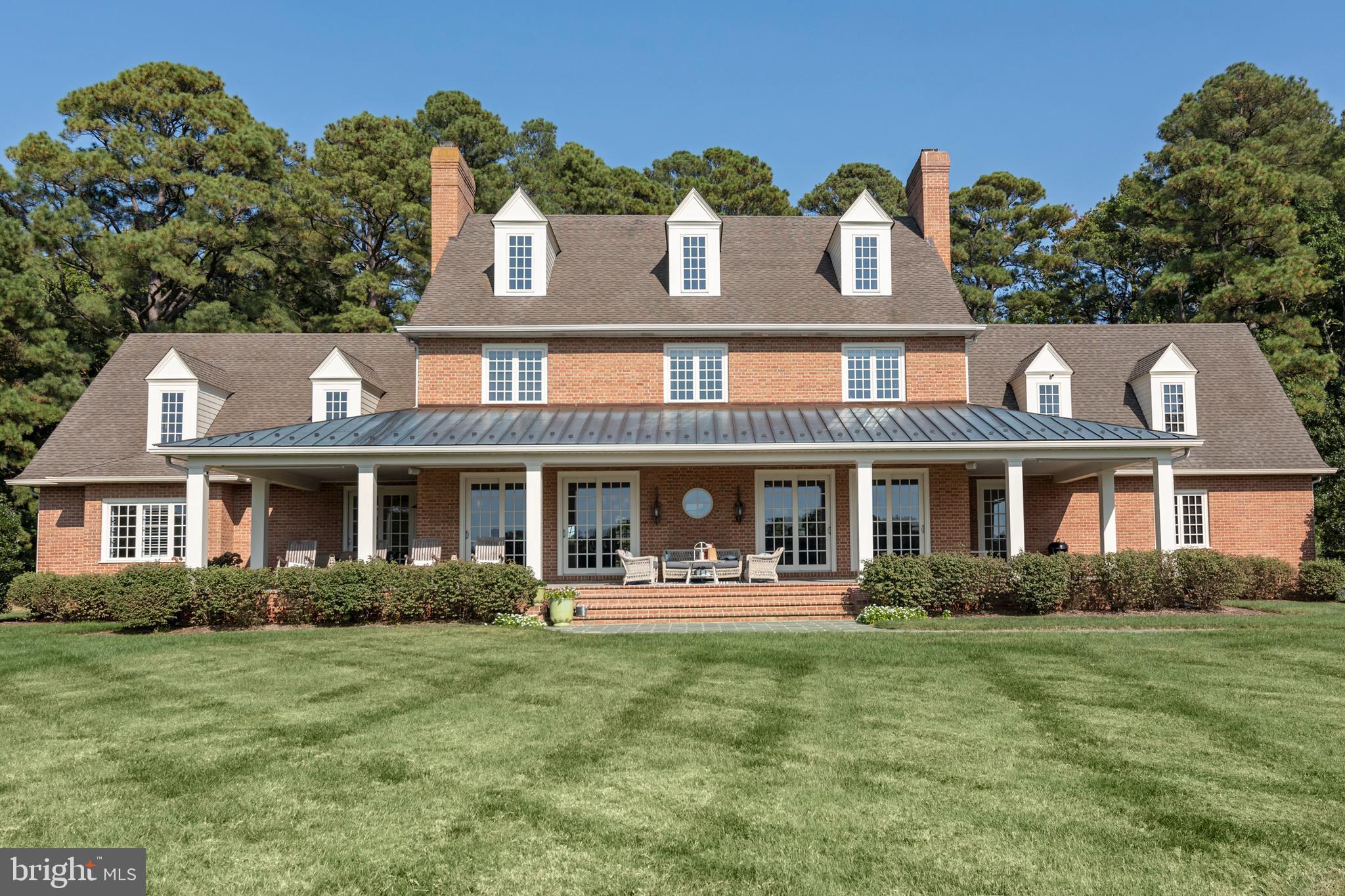 Welcome to Idylwood, a stunning waterfront estate in Easton, MD, ideally located between historic Easton and St. Michaels with quick boat access to Oxford. Known as the "New Hamptons of the Chesapeake Bay" by Forbes, Easton is just 1.5 hours from D.C. and Baltimore, and 2 hours from Philadelphia, making Idylwood an accessible luxury retreat. Recently remodeled and updated, the home features modern conveniences and enhanced energy efficiency, blending timeless design with contemporary comfort. The all-brick construction features 10' ceilings, antique pine floors, and top of the line Eagle/Anderson windows and doors. The interiors are spacious and elegant, featuring three wood-burning fireplaces that add a cozy ambiance. The home is incredibly quiet and well-insulated, providing a peaceful and energy-efficient living environment. The first-floor primary suite opens to a bluestone waterside porch with breathtaking sunset views. The second floor includes a game room and four bedrooms with en-suite bathrooms, while the third floor offers a thoughtfully designed guest suite for visitors or extended family stays that can be zoned off when not in use.
A private gated entrance ensures security and privacy, with the estate’s layout offering the feel and privacy of a larger property but with minimal maintenance. The charming guest cottage complements the main home, featuring a garage, brick-floored kitchen/family room, wood-burning fireplace, and private bedroom/bathroom. Outdoor amenities include a waterside pool and pool house, a fire-pit, a sandy beach shoreline for kayaking and fishing, a 158' x 6' dock with deep-water slips, boat and jet ski lifts, and 6' MLW depth—perfect for yachts or sailboats. Modern features elevate comfort and convenience, including fiber high-speed internet, whole-house and yard mesh Wi-Fi, a Sonos music system, a security system, Invisible Fence, and a multi-zone HVAC system (installed 2024). Sold furnished (with a few exceptions), Idylwood combines architectural excellence, luxurious amenities, and serene living, making it the ultimate turnkey home or retreat.