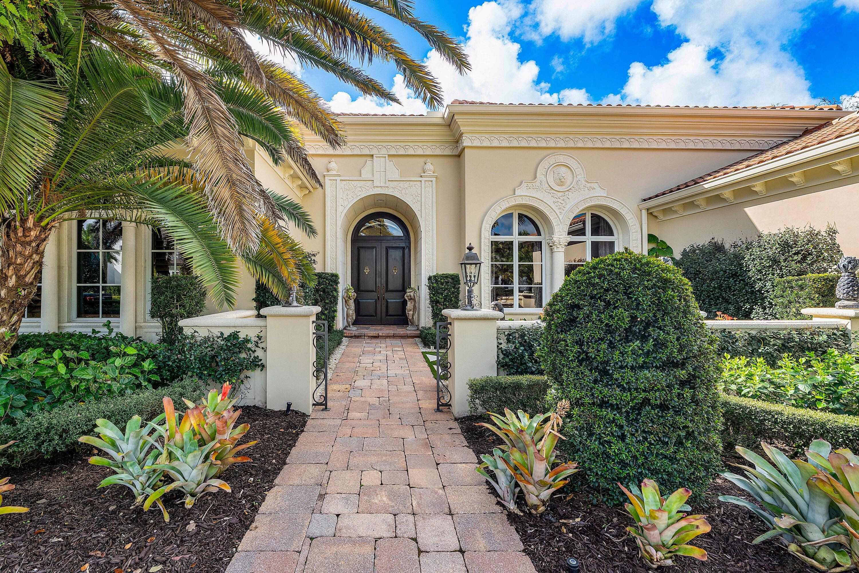 Grand Estate Living in Prestigious Old Palm Golf Club
Situated on one of the largest and most private homesites in the coveted Grand Estates at Old Palm, this exceptional single-level residence embodies timeless elegance and refined luxury. This sprawling estate features 4 bedrooms and 4.5 baths, along with a fully air-conditioned three-car garage equipped with electric vehicle charging, offering both comfort and functionality. A grand mahogany front door welcomes you into an interior rich with architectural detail, including marble and hardwood flooring, exquisite custom built-ins, dramatic designer lighting, and elegant custom window treatments throughout.
Each spacious bedroom offers the privacy of its own en-suite bathroom, creating a perfect retreat for family and guests alike. At the heart of the home, the chef's kitchen is equipped with high-end appliances and designed for both entertaining and everyday living. The adjoining living space is enhanced by a stunning and grand natural gas  fireplace, adding warmth and sophistication.
Outdoor living is equally impressive. The expansive backyard retreat showcases an oversized heated pool and spa, surrounded by marble stone pool decking, lush tropical landscaping, and a fully equipped summer kitchen, ideal for year-round entertaining. The home is further enhanced with hurricane impact windows throughout, a recently replaced tile roof, and new exterior paint, ensuring both beauty and peace of mind.
While located within the prestigious Old Palm Golf Club, this unique residence offers the rare advantage that club membership is not mandatory, allowing homeowners to enjoy privacy and luxury on their own terms.
With exceptional privacy, expansive grounds, and timeless design, this remarkable estate offers the ultimate Palm Beach County luxury lifestyle.