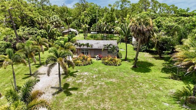 Welcome to your private slice of Loxahatchee! Situated on a beautifully maintained and fully fenced 1.34-acre lot, this unique property offers the perfect blend of country living, flexibility, and convenience with no HOA restrictions. The main residence features 4 bedrooms, 2 bathrooms, and 1,420 square feet of living space, while the detached 2-bedroom, 2-bath guest house provides endless possibilities for extended family, guests, a home office, rental income potential, or multi-generational living. As you enter through the palm-lined driveway, you'll immediately appreciate the mature landscaping, wide-open green space, and peaceful setting. The property includes a private pond, RV hookup, storage areas, and plenty of room for boats, trailers, work vehicles, animals, gardens, and all  your outdoor toys. Enjoy relaxing under the covered patio, entertaining family and friends, or simply taking in the privacy and tranquility this property has to offer. Conveniently located just minutes from shopping, dining, schools, and major roadways, while still maintaining the space and freedom that make Loxahatchee so desirable. Rare opportunity to own a versatile acreage property with a detached guest house, no HOA, and room to grow. Schedule your private showing today!