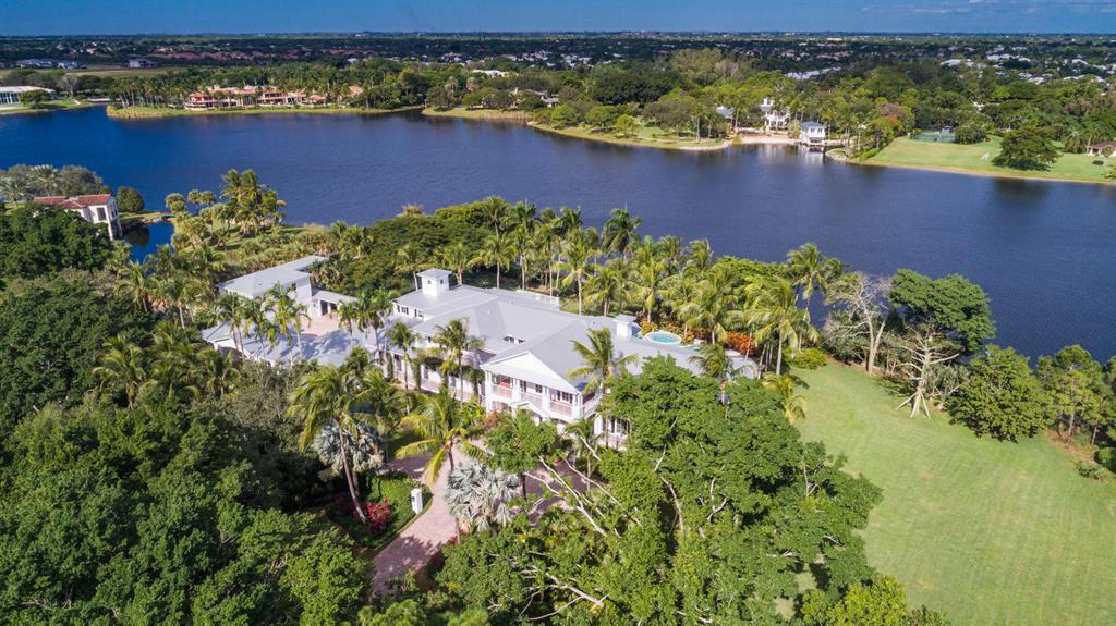 This two story Coastal-style-estate, on almost 4 acres of secluded and tropically landscaped grounds, has over 600 feet of direct water frontage, offering exceptional lake views from almost every room in the residence.  The first floor features a grand two-story foyer that flows seamlessly into the formal living room with fireplace, billiard room and formal dining room.  The kitchen, butler's pantry and family room comprise the center of the home.  An in-law suite and office/library are at the end of the central hall.  The seven-car auto court has an air-conditioned bay for storage.  The second level features a spacious master bedroom suite with sitting room and wrap around veranda, 3 ensuite bedrooms with outdoor terraces and an activity room.  The second level also includes an 
MORE... exercise room and an upstairs laundry.  A two room second-story guest house is accessible from the main residence via a covered walkway. The covered lanai opens to the pool and patio area with waterfall spa and outdoor kitchen, all with exceptional lake vistas.  Le Lac is the only navigable lake in Boca Raton: boating, jet skiing, standup paddle boarding, canoeing and kayaking are available from the property's private dock or community launch.  A Har-Tru/Fast-Dry composition tennis court with gazebo is at the end of the expansive lawn.  These amenities as well as security and unparalleled privacy are all part of this unique property's lifestyle.

PROPERTY DETAILS AND AMENITIES:  

Two-story grand entrance foyer in neutral marble, rich dark hardwood floor living room with fireplace overlooking the pool and center portion of the lake.

First Floor:
Main first floor office library with magnificent hardwood built-ins and exceptional views of the grounds and lake. 
First floor utility currently being used as a secondary office
Spacious first floor bedroom suite
7-car garage (one bay currently being used as an air conditioned storage area)
The spacious master suite showcases some of the most magnificent views and includes the main master bedroom, his and her walk-in closets, a coffee bar, the master bathroom with separate water closets and a Roman shower.
A sitting room off the master has sensational views of the lake, grounds, tennis courts, gazebo and exquisite tropical landscaping.

Utility room upstairs (additional first floor utility currently being used as a secondary office/storage area)

A two room/second story guest house, features a living room with kitchenette and guest bedroom suite, which are all accessed via a covered walkway.
1000 gallon propane tank serves the kitchen appliances, grill, pool heater and dryer.  A propane generator powers a majority of the house and essentials. 

Public water /septic tank/drainage field system on the on the east side of the property.  As of 2017 the community went to an option of going from well to city water, which the sellers chose to do. 
Prior filtration system still exists on west side of the house adjacent to the garage and can be used to water the hydro-tennis courts as it is currently watered via county water. 

Seven-car garage, one of which is being used as an air-conditioned storage room.
Landscape irrigation is from the lake.
There is a propane pool heater tied to the 1000 gallon tank that heats the spa, with capacity to add an electric heat pump for the pool itself.
The pool equipment is a Jandy system that is accessible through the Internet.
Eight air-conditioning systems, three are original, five have been replaced.
Home security monitoring system separate from the main guard gate.
Magnificent first and second floor exterior verandas with clay tile walkways
Coastal design constructed with 'Hardie board' exterior ceiling and siding material for minimal maintenance and durability 
Aluminum roof /exterior sconces and lantern light fixtures
Bougainvillea clad exterior landscaping 
Main entry foyer staircase/back staircase off family room and elevator

Game Room: 
Entertainment/media/ billiards/bar area with light hardwood wall and ceiling paneling, located on the eastern portion of the house with panoramic views of the lake, magnificent grounds and the tennis court with separate gazebo

Dining room: 
Sensational views of the covered patio pool/open pool and patio/ waterfall spa and lake as well as exquisite tropical landscaping

Expansive Kitchen: 
White wood cabinetry with butler serving area.  Marble-top islands that serve the family room and dinette, with views of veranda, pool/patio and lake
6-burner gas wolf appliances
Oversized pantry 
Wine room with refrigerator storage 

Second floor: 
Elevator to the second floor
A hardwood galleria services all Bedrooms including suites 2 and 3 and activity room that opens to the second floor open terrace.
Bedroom suite 4 has a steam shower and opens to a covered terrace that spans the entire front of the residence.
An Exercise room with double entry doors opens to a covered terrace with lake views.
The spacious master suite showcases some of the most magnificent views and includes the main master bedroom, his and her walk-in closets, a coffee bar, the master bathroom with separate water closets and a Roman shower.
A sitting room off the master has sensational views of the lake, grounds, tennis courts, gazebo and exquisite tropical landscaping.

Utility room upstairs (additional first floor utility currently being used as a secondary office/storage area)

A two room/second story guest house, features a living room with kitchenette and guest bedroom suite, which are all accessed via a covered walkway.
1000 gallon propane tank serves the kitchen appliances, grill, pool heater and dryer.  A propane generator powers a majority of the house and essentials. 

Public water /septic tank/drainage field system on the on the east side of the property.  As of 2017 the community went to an option of going from well to city water, which the sellers chose to do. 
Prior filtration system still exists on west side of the house adjacent to the garage and can be used to water the hydro-tennis courts as it is currently watered via county water. 

Seven-car garage, one of which is being used as an air-conditioned storage room.
Landscape irrigation is from the lake.
There is a propane pool heater tied to the 1000 gallon tank that heats the spa, with capacity to add an electric heat pump for the pool itself.
The pool equipment is a Jandy system that is accessible through the Internet.
Eight air-conditioning systems, three are original, five have been replaced.
Home security monitoring system separate from the main guard gate.
House built on 3.85 acres on the center of the lake Le Lac in Boca Raton, Florida
Le Lac provides 24/7 manned guard gate security. 
Roads and lake are private for resident use only

All buyers to the Le Lac community are required to pay a 1.5% of purchase price fee to the Le Lac Homeowners association as a one-time capital contribution. See Listing office for further community information.