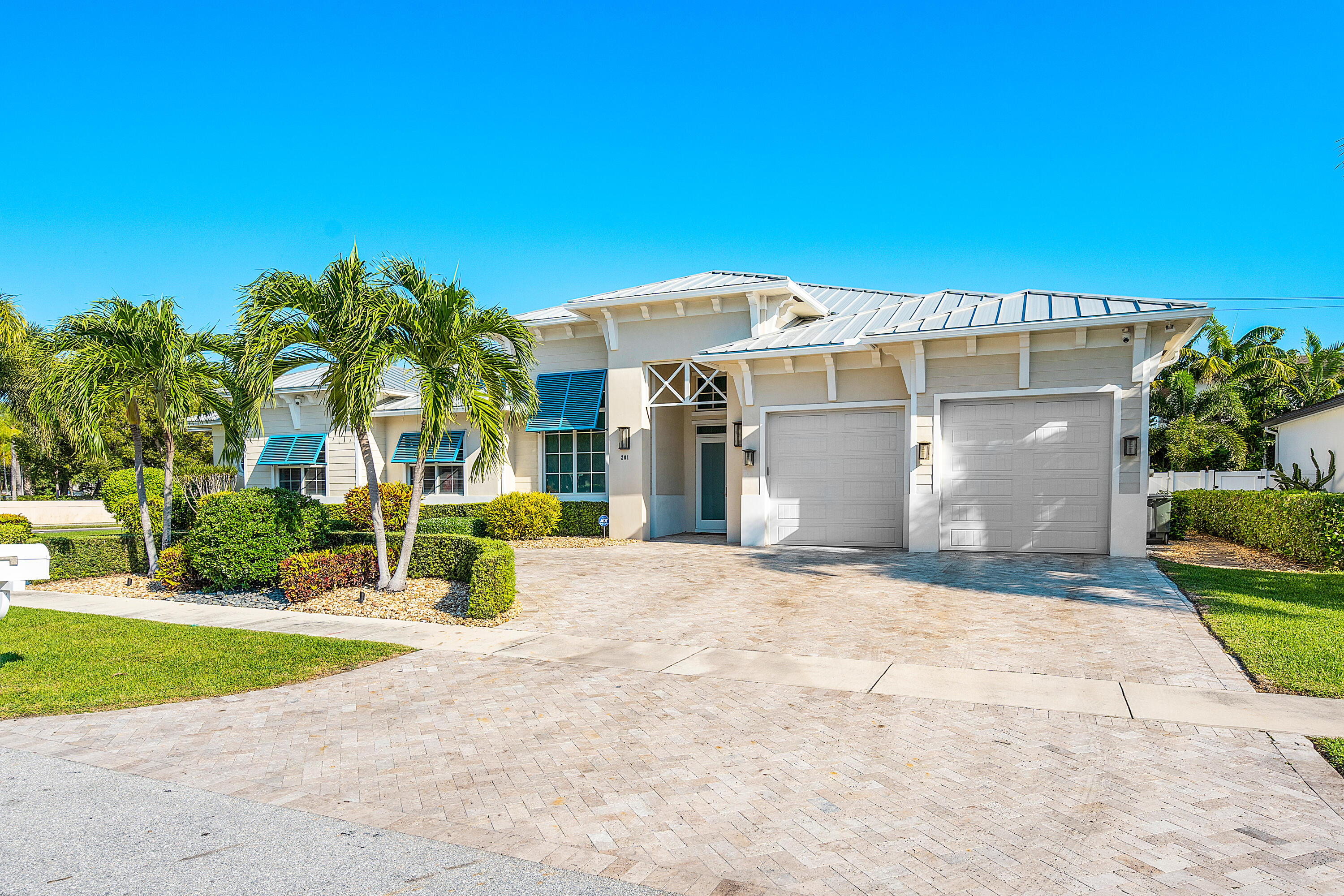 Rarely available single-story estate located on a corner lot just one block from Mizner Park! A coastal style home with modern features, volume ceilings, expansive glass and so much more! The updated kitchen features gas cooking, three ovens, two sinks, beverage center and one of the largest islands in East Boca. The adjacent bar is perfect for entertaining, within the stunning great room overlooking pool. The patio features a large covered area, overlooking saltwater pool, surrounded by shell stone pavers, with a large grassed area, perfect for dogs and playsets. Back inside, you'll find the primary suite with two large closets, spa bath, and separate sitting room soaked in light. A VIP suite is perfect for special guests, while two additional bedrooms share a large ensuite bath. The private office provides city views, or can be utilized as a fifth bedroom. An exceptionally built home By Elysee Homes, with standing seam metal roof, full house generator, car charger, and so much more. This IS downtown Boca living.