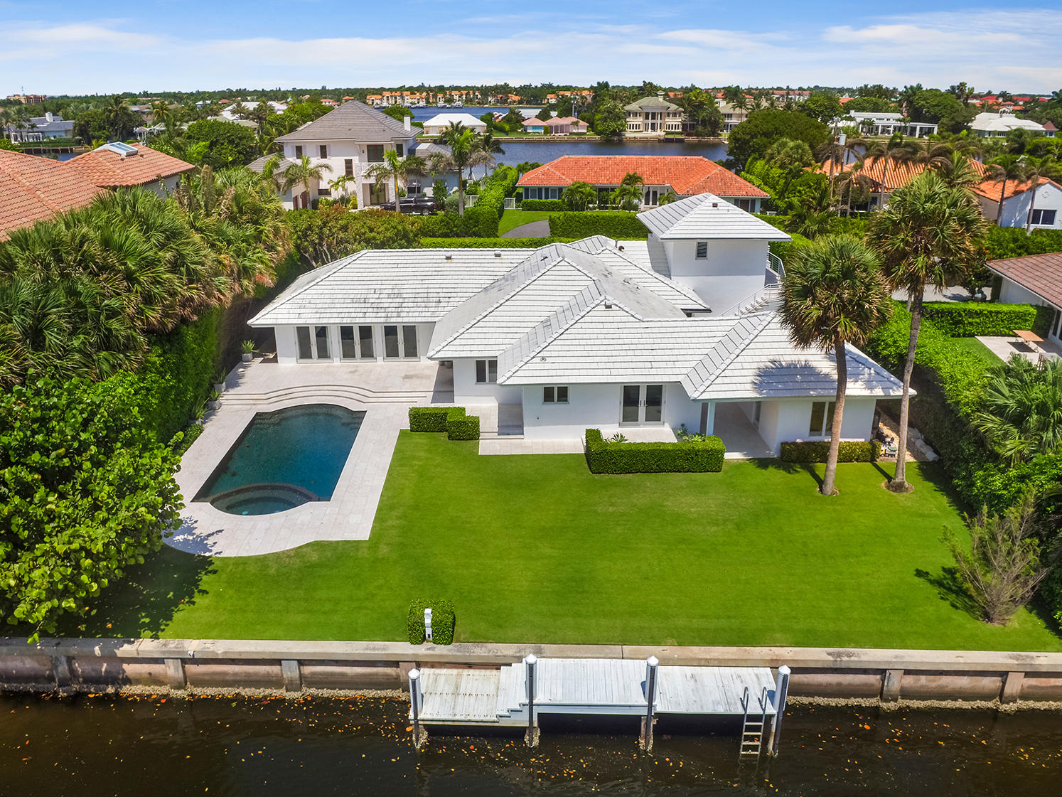 Step inside this stunning renovation of a waterfront home in Manalapan. Situated on this very quiet road that feels almost private with over 100 feet of water-frontage and direct ocean access only a few minutes boat ride away. Enjoy an open floor plan from this one story home with great ceiling height throughout. Three bedrooms, three and a half baths with a two car garage make up the main part of the house with a guest apartment over the garage. There is also a cabana/bedroom in a separate structure leading to the garden. French doors lead to a spectacular pool and private dock for some afternoon fishing/boating. Enjoy ocean breezes with complete privacy from mature manicured landscaping. This property also has private beach access and membership to La Coquille Club at the Eau Palm Resort
