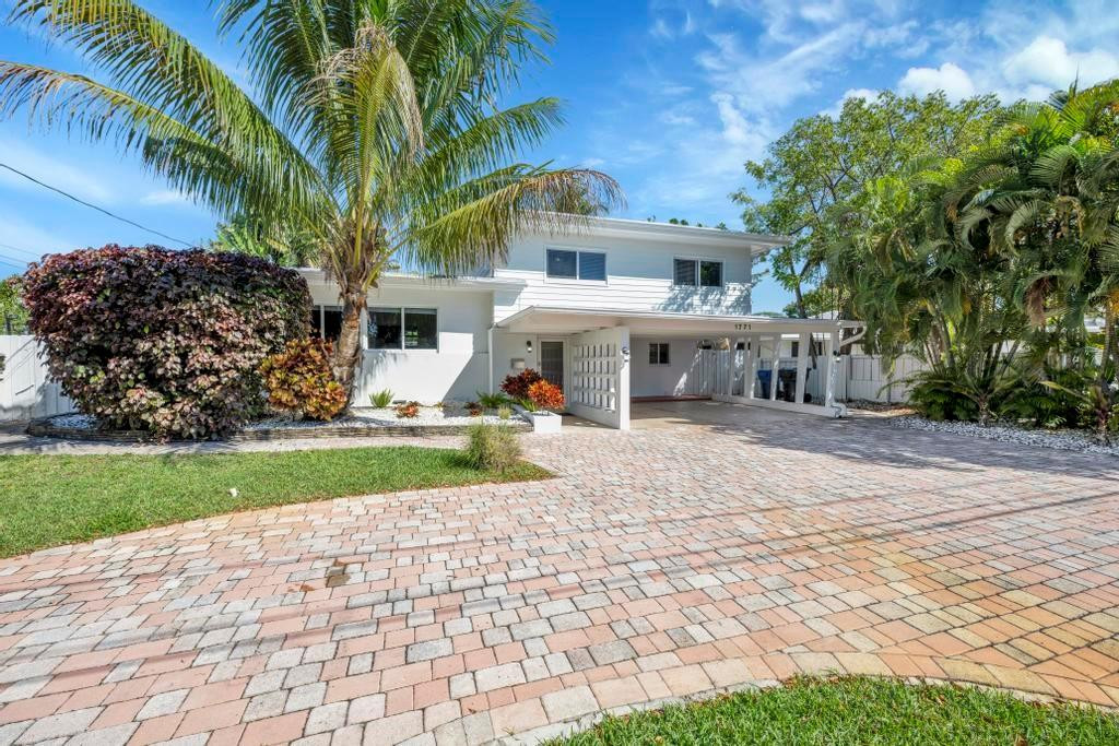 Coastal Gem with 70 Ft of Water Frontage. Remodeled single family home with newer seawall and hurricane impact windows and doors for peace of mind. The home boasts a three-level floor plan, featuring an upgraded kitchen with wood cabinetry, stainless steel appliances, and a gas stove. With 3 bedrooms and 2.5 baths, the bright and airy interior is designed for comfort and style. Step outside to your private tropical oasis, where tall palms, mango, lime, and banana trees surround a screened-in patio and an oversized saltwater pool, all overlooking the serene Cherry Creek Canal. The curb appeal is undeniable, with lush landscaping and ample parking in the carport and circular driveway. Nestled on a quiet cul-de-sac in a sought-after neighborhood, this home is a rare waterfront find!