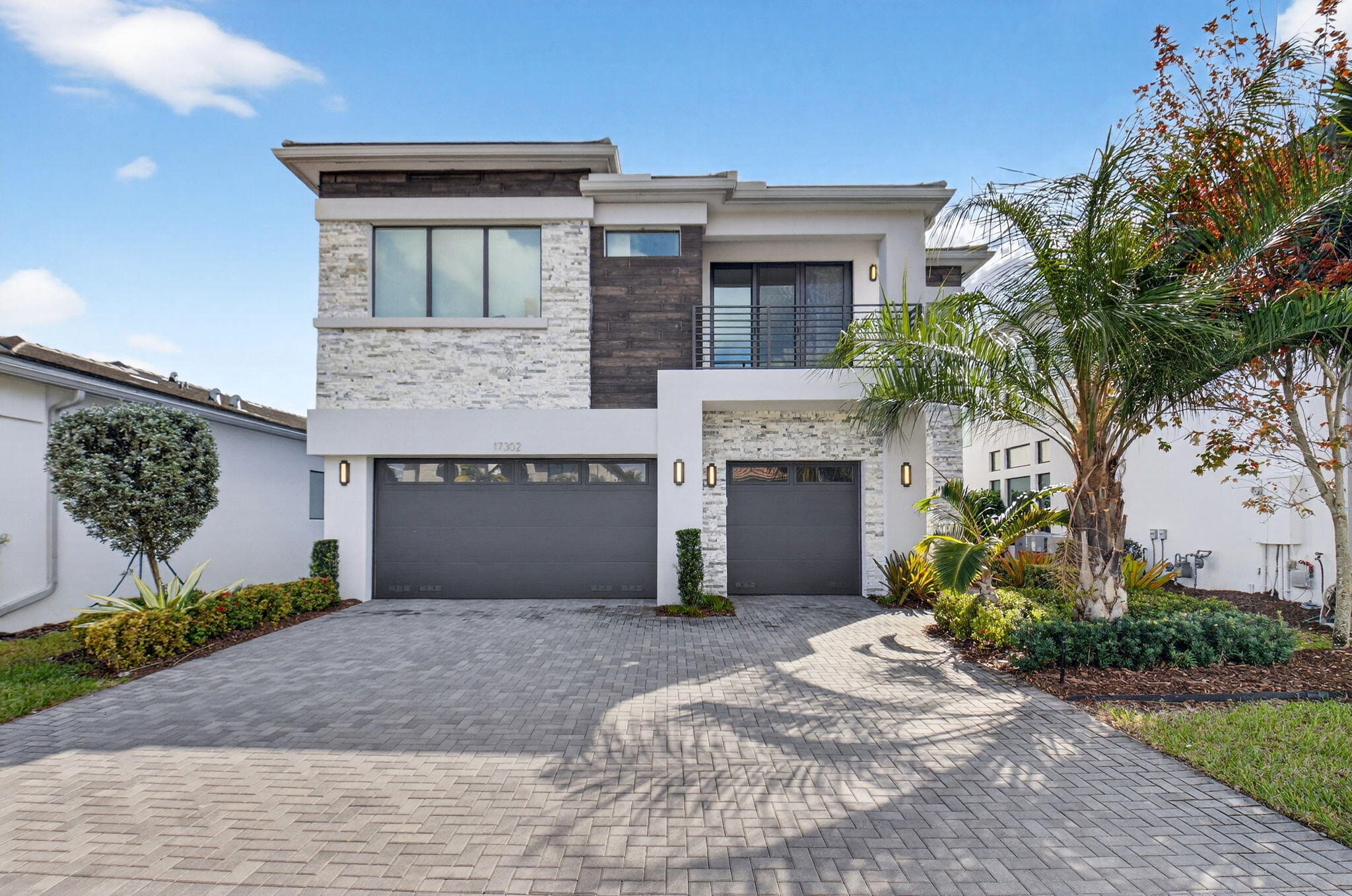 This exceptional Honolulu model offers 5 bedrooms plus a loft, 5 bathrooms, and a 3-car oversized garage, perfectly positioned on a lakefront lot with southern exposure and a custom pool. A grand entry with soaring ceilings opens to an expansive great room featuring a built-in wall unit with fireplace and wet bar—ideal for entertaining.   The gourmet kitchen is thoughtfully designed with upgraded cabinetry, quartz countertops, a large center island, and a spacious dining area. Premium stainless steel Wolf appliances and a Miele refrigerator complete the space. Just off the kitchen, a large walk-in pantry and custom built-in mudroom provide abundant storage. The first floor is rounded out by a bedroom and a full bathroom. Upstairs, hardwood floors lead to a spacious loft highlighted by a unique built-in desk and wall unit. The primary suite is a true retreat, offering two oversized walk-in closets and a spa-inspired bathroom with a freestanding soaking tub. Three additional bedrooms are located upstairs, two with en-suite bathrooms. A conveniently located laundry room features built-in cabinetry and classic subway tile. Additional highlights include impact-resistant windows and doors, gas appliances, and refined finishes throughout. Located in the sought-after, resort-style community of Lotus, residents enjoy a restaurant and bar, heated pool and whirlpool, tennis and pickleball courts, fitness center, playground, and more. Ideally situated near Delray Beach, this home offers quick access to dining, shopping, beaches, and is zoned for A-rated schools.