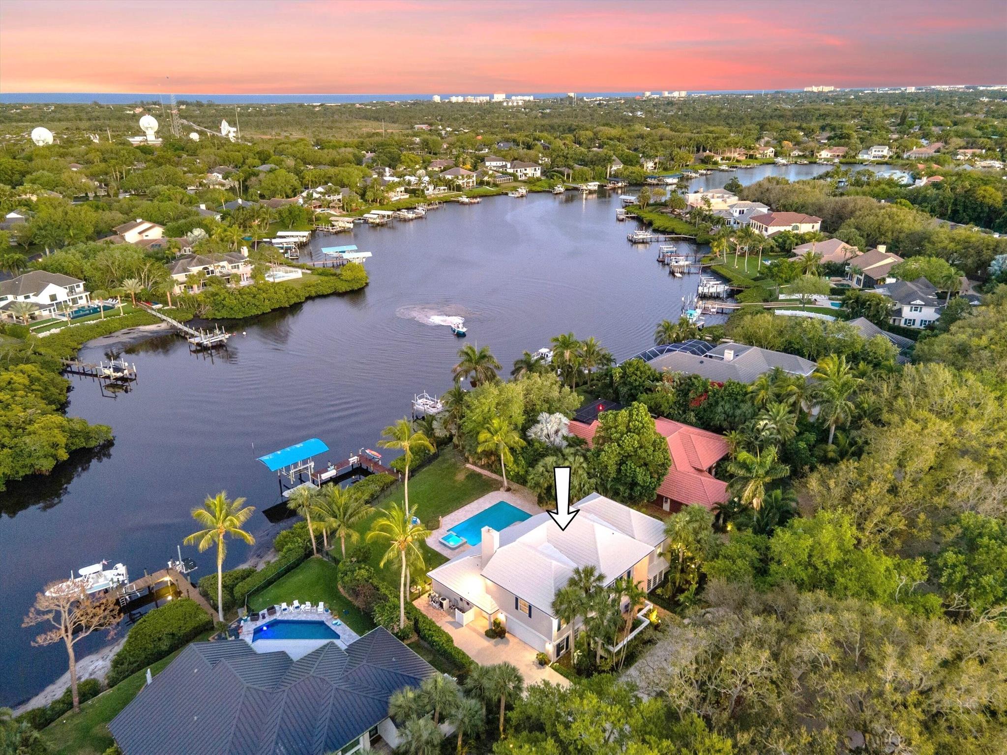 Discover this spectacular riverfront estate nestled along the North Fork of the Loxahatchee River in the prestigious gated community of Heritage Oaks. Set on a generous half-acre lot, this exquisite 4-bedroom, 4.1-bath home spans over 4,800 sq. ft. of meticulously designed living space. Built with solid CBS construction, it features ALL impact doors & windows, a hurricane-rated newer roof, and advanced foam/icynene insulation, ensuring long-term durability and energy efficiency.
Upon arrival, a Chicago brick driveway and walkway lead to a grand two-story foyer, where the home's elegant charm is immediately evident. The formal living and dining rooms capture stunning river views, complemented by French doors opening to a private side patio and fountain. A first-floor den/office offers additional privacy, featuring French door access to the front patio. The two-story family room, with its inviting fireplace and open loft above, creates a warm and welcoming atmosphere with breathtaking views of the river.
Some of the recent renovations include  gourmet custom kitchen with an island, custom white cabinetry, soft-close features, mitered 6cm quartz countertops, a stylish tile backsplash, farmhouse sink, and stainless steel appliances. Newer stained wood flooring extends throughout, adding to the home's warmth and sophistication. Additional recent renovations include a newly updated dock with electric & water connections, a 12K lb boat lift, and a new boat canopy, ensuring an effortless boating experience.
The spacious master suite serves as a private retreat, offering a cozy sitting area, dual walk-in closets, and a spa-inspired bath with dual vanities and a luxurious double shower featuring a rainfall showerhead. A first-floor guest suite, mudroom, and a finished laundry room add both convenience and functionality to this exceptional residence.
The outdoor living space is nothing short of a private waterfront oasis. A new travertine marble patio surrounds a resort-style saltwater pool with a newer heater, complemented by an outdoor shower, a screened-in porch, and a whole-home generator with a buried propane tank.
For boating enthusiasts, this property is a dream, featuring a private dock with full electric & water hookups, a boat lift, and direct access to some of Florida's best fishing, snorkeling, and boating destinations.
Located within Heritage Oaks, residents enjoy the beauty of oak-lined streets, a world-class tennis facility, and an inviting clubhouse, creating a secluded yet conveniently located community. Situated in sought-after Tequesta, this home is just minutes from top-rated schools, fine dining, world-class shopping, and pristine beaches. Don't miss this rare opportunity to own a true riverfront paradise! Schedule your private showing today!