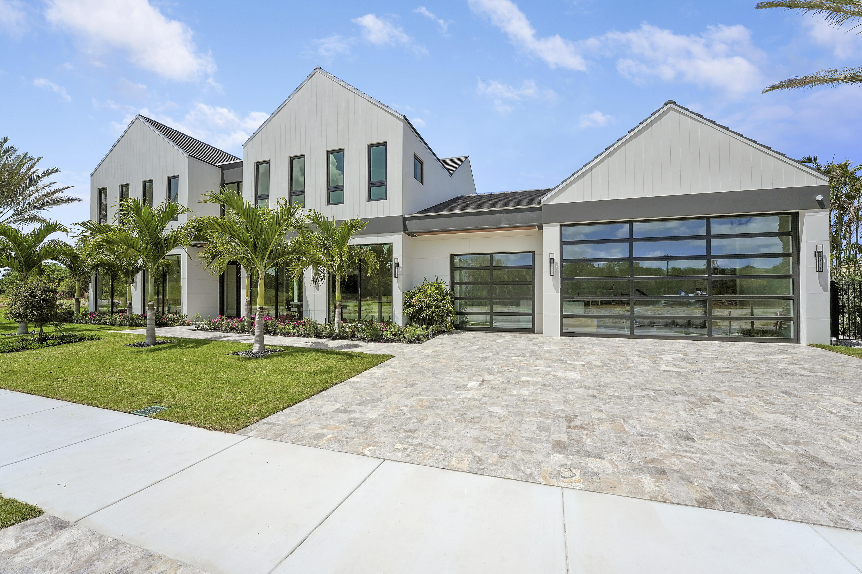 Welcome to Farrell Estates, an elite collection of 27 bespoke residences within the prestigious Palm Beach Polo Club. Introducing Lot 1, a masterpiece of modern luxury boasting premier, unobstructed views of the historic old golf course. This residence epitomizes Hamptons-style indoor-outdoor living, centered around an expansive open floor plan. Walls of glass and sliding doors invite natural light to dance across wide-plank light oak floors and stunning quartzite surfaces. The chef's kitchen features custom cabinetry, while the downstairs Junior Suite offers serene pool and spa vistas. Complete with a three-car garage and over 1,000 sq. ft. of covered patio space, this home is designed for the most discerning lifestyle enthusiast. Experience the pinnacle of Farrell Estates! The elevated experience continues upstairs, accessible via a personal elevator. The primary wing is a private sanctuary, featuring a dedicated terrace for morning coffee or evening cocktails overlooking the rolling fairways. Three additional guest bedrooms, each with a private ensuite, ensure absolute comfort. A massive 1,000+ sq. ft. open-air terrace provides the ultimate venue for sunset entertaining. No detail has been overlooked: 2.25-inch solid core doors and dual laundry centers (upstairs and downstairs), each equipped with double washers and dryers, highlight the thoughtful utility behind the design. This is more than a home; it is a curated lifestyle of sophistication and ease. Discover the bespoke elegance and unparalleled craftsmanship of Farrell Estates today.