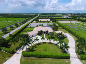 This 5 bedroom, 6 bath home built for entertaining, is set on 5.0 acres and features top of the line finishes, including marble floors, heavy moldings and an extensive music system inside & out. The designer kitchen, with chef's center island, offers double ovens and double dishwashers. The master suite is complete with his & hers walk-in closets and his & hers shower. The home also features brand new Trane A/C system. A large screened pool area overlooks the dressage ring and 12-stall barn. The pool area has been renovated to include a new travertine pool deck, new glass tiles in the pool & spa, new patio fans, and a saltwater system for the pool. The barn is finished with central fly-spray, tongue and groove ceiling, hurricane shutters & roll-down doors. Included in the barn are 2 apartments, 1 with lounge, additional half bathroom, tack room, and double laundry system. New dressage mirrors have been installed in the 120 x 220 arena. The property is complete with two security gate entrances for added privacy, reverse osmosis water treatment system, separate septic system for horse showers and a 4 car garage with automatic openers that can be converted into a carriage house.