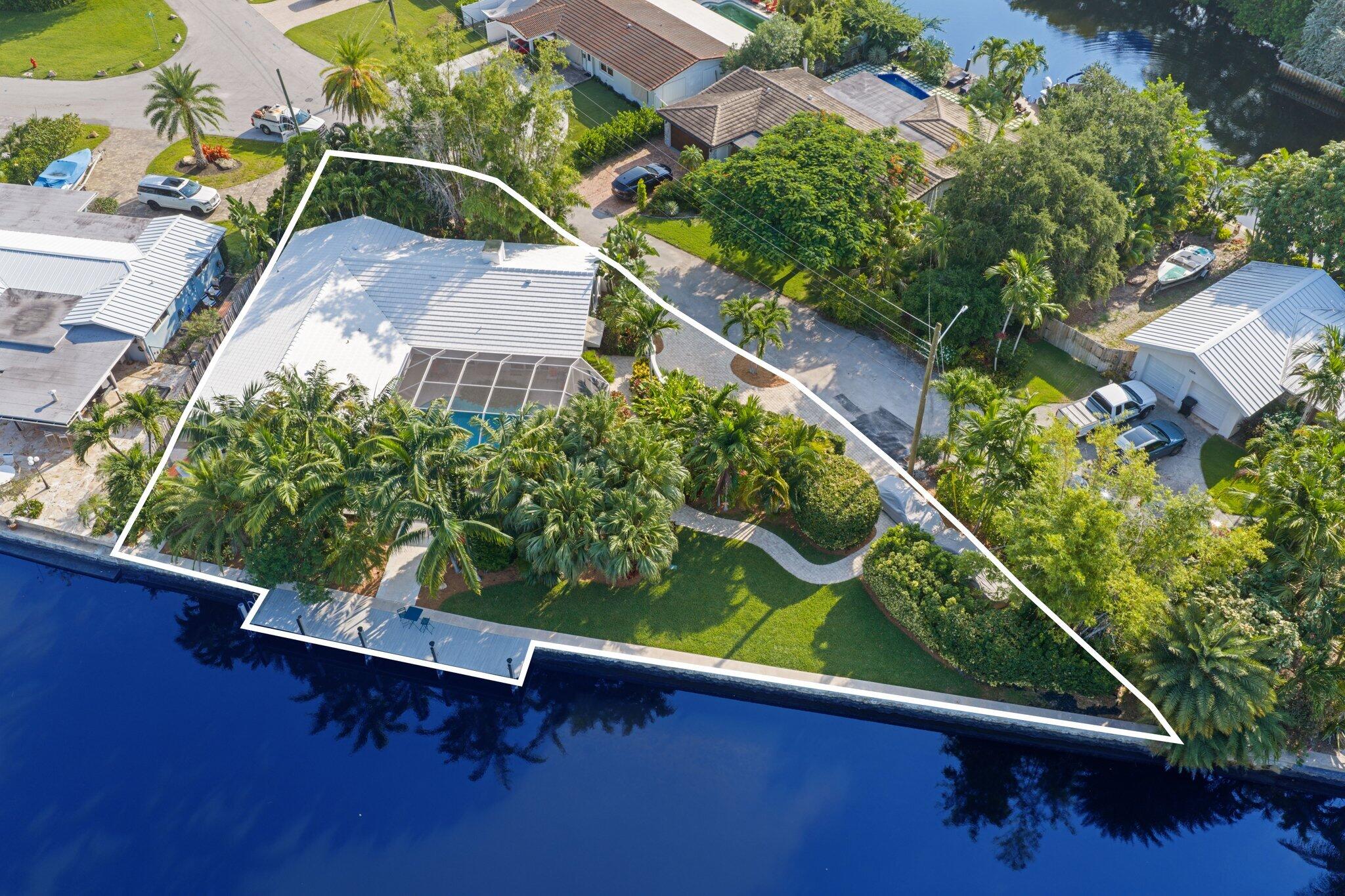 Set along 177' of maturely landscaped wide waterfront, 2124 Coral Shores Dr is a rare, private oasis like no other. Every surface was hand selected and renovated down to the studs. An entire wall of floor to ceiling glass pocket doors introduces the indoor/outdoor living space that defines this home. With exceptional views of the pool and water, the open living rooms are anchored by a double sided fireplace. The kitchen features handcrafted Astra Italian cabinetry, two dishwashers and a Fisher & Paykel gas range, blending refined materials with modern function. Outside, the oversized waterfront lot is accentuated by mature, layered landscaping and a screened in, heated pool creating a five star worthy oasis. Recently replaced roof, plumbing, electrical and impact windows/doors.