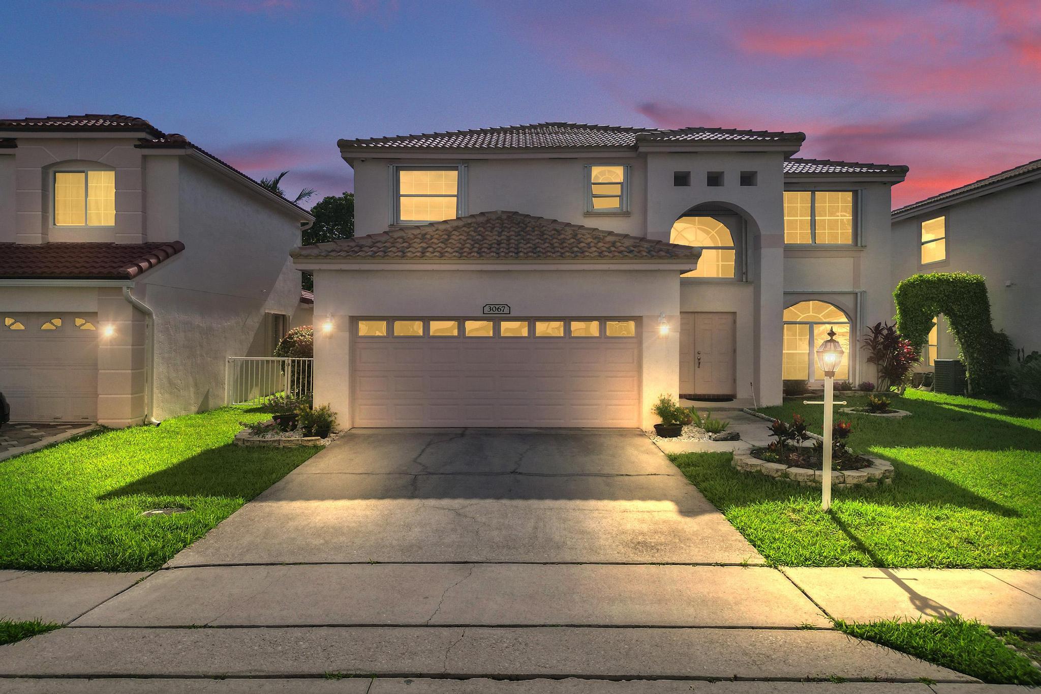 Gorgeous lakefront 4-bedroom, 2.5-bath, 2-car garage home in the popular Woodlands at Carolina featuring a brand new roof! This beautifully maintained home offers stunning water views and an expansive enclosed patio, perfect for enjoying the sunset. Interior features include marble floors in the living areas and primary bedroom suite, a spacious primary bath with a jacuzzi tub, and tastefully updated kitchen and bathrooms. Impact glass and accordion shutters provide complete storm protection, while a 360-degree camera system with motion detectors adds an extra layer of security. The well-landscaped, fenced backyard offers privacy and outdoor enjoyment. The community pool is just a short walk away for those warm summer days. Low HOA Close to shopping.