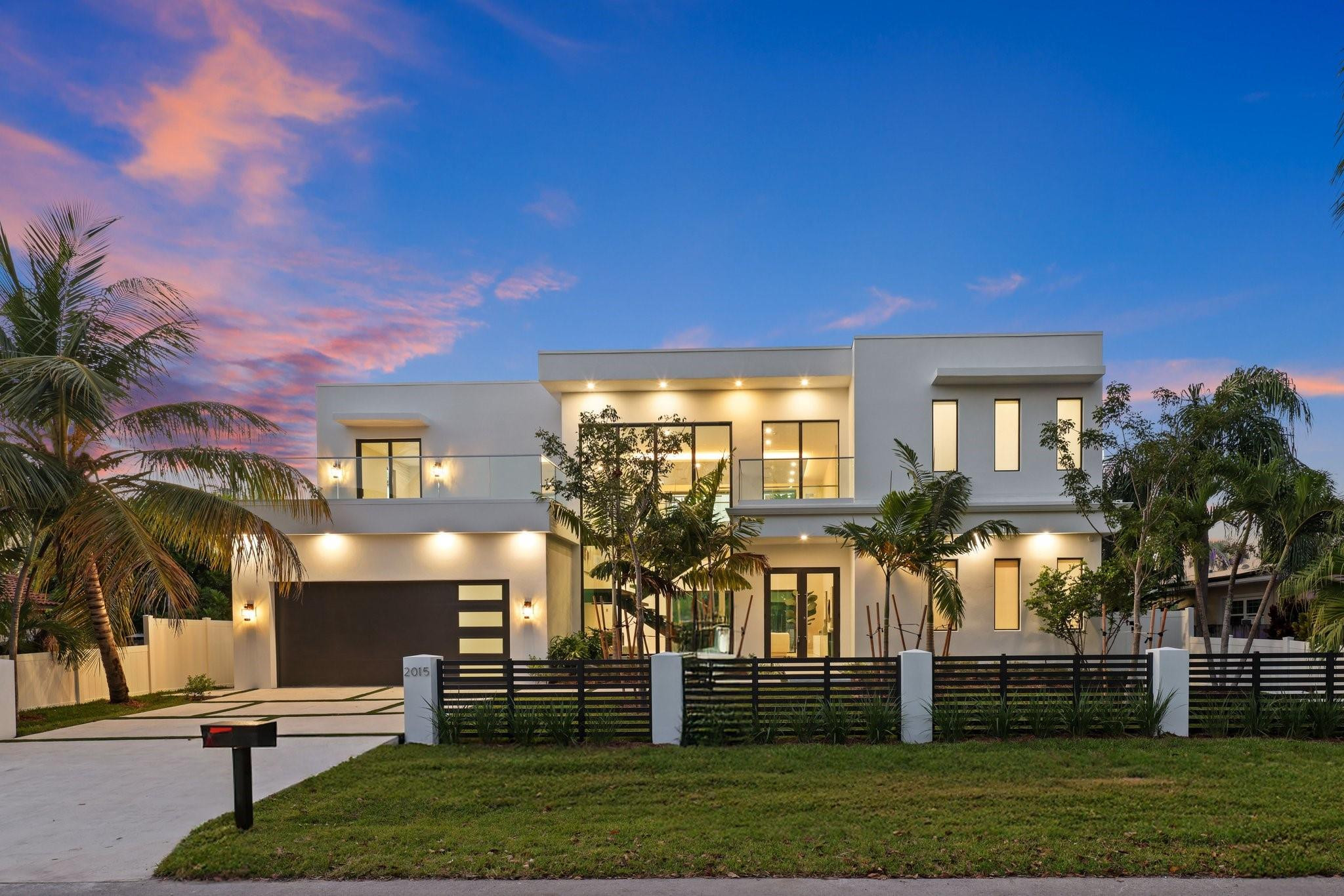 Modern elegance & architectural sophistication define this Wilton Manors home spanning 3,755 SQFT with 4BD, 4.5BA, & 2-CG. Featuring a floating glass staircase, private elevator, and soaring 24' ceilings, Filled with natural light. Italkraft cabinetry, quartz countertops, Miele appliances, and wine cooler complement the sleek interior. Two identical primary suites—one on main level & additional upstairs—plus two guest bedrooms connected by an enclosed glass catwalk overlooking the living area. Additional features include prewired sound system, stackable washer/dryer upstairs, full laundry room on main level, surrounded by tropical landscaping with an outdoor kitchen, saltwater oversized spa and plunge pool with waterfall feature. Designed & Built by Atlantic Group Developers.