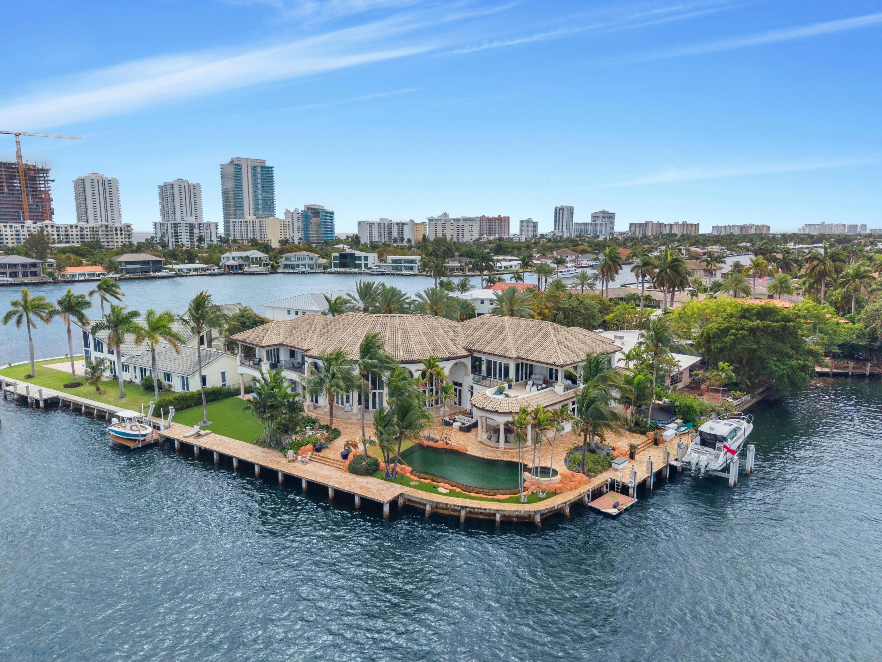 Set on a coveted point lot where the Intracoastal meets Lake Santa Barbara, this exceptional waterfront estate offers over 270 feet of prime dockage, accommodating multiple large vessels with ease. Sweeping wide-water views create a spectacular backdrop of sunrises, sunsets, and passing yachts. The residence is fully renovated and shows impeccably, blending luxury with functionality. Features include an elevator, gym, office, movie theater, and full home automation. A five-car garage with the ability to add lifts provides ample space for car enthusiasts. Offered furnished or unfurnished, this turnkey property delivers the ultimate South Florida waterfront lifestyle just minutes from the beach and top dining. Rare point lot with over 270 feet of waterfront offering exceptional dockage for multiple large vessels with direct ocean access and no fixed bridges. Positioned at the junction of the Intracoastal and Lake Santa Barbara, the property enjoys some of the most expansive water views in the area. Fully renovated residence with elevator, gym, office, and private theater, designed for both luxury living and entertaining. Five-car garage with the ability to add lifts for additional capacity. Full home automation throughout. Offered furnished or unfurnished for immediate enjoyment. Ideal as a primary residence, seasonal retreat, or trophy waterfront investment.