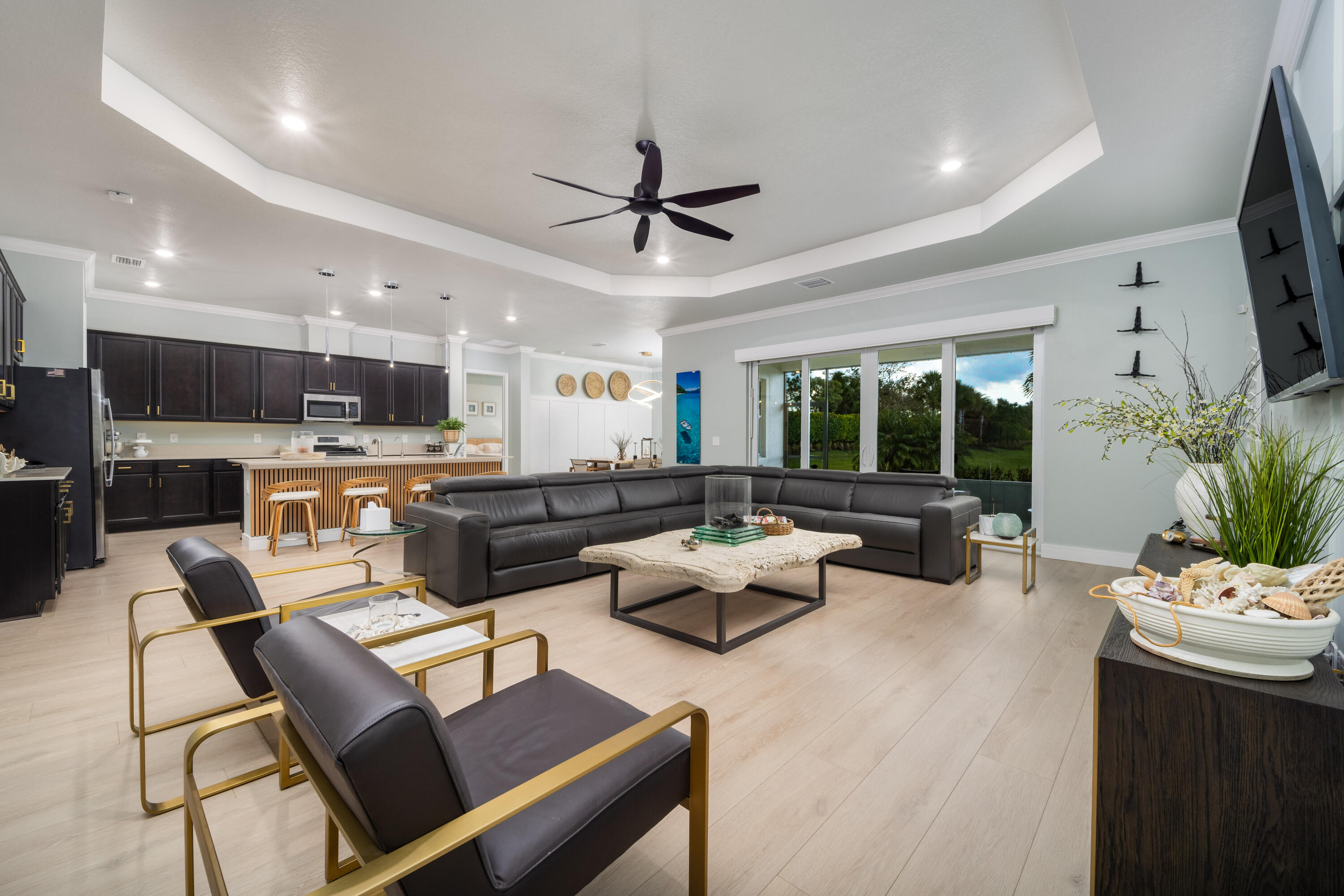 JUST REDUCED! LOW HOA 55+ COMMUNITY IN PSL.  Welcome to 642 Southeast Goldenrod Road, located within the prestigious Veranda Preserve, an exclusive 55-plus community in Port St. Lucie, designed for refined Florida living. This beautifully appointed residence offers three generous bedrooms, a den, and four bathrooms, providing exceptional space, privacy, and flexibility. The home's expansive open-concept layout is ideal for elegant entertaining, seamlessly flowing to peaceful lake views that create a calm, private, and serene setting-enhanced by newly updated flooring throughout that keeps the home light, bright, and inviting. Completing the living space is a screened-in lanai with tranquil lake views, offering the perfect setting to relax, unwind, and enjoy Florida living year-round.  Every detail of this home reflects thoughtful design featuring extensive high-end upgrades throughout. Highlights include a striking custom front entry door, Indian River shutters, upgraded ceiling fans, designer wall accents, and timeless crown moldings. Modern conveniences include a whole-home water purification system, tankless water heater, natural gas service, and a whole-home generator, offering comfort, efficiency, and peace of mind year-round.  The three-car garage is a standout feature, finished with RaceDeck diamond plate garage flooring, upgraded ceiling lighting, and custom wall graphics--creating a polished, functional, and visually impressive space. Residents of Veranda Preserve enjoy a resort-style lifestyle, with access to a beautifully appointed clubhouse, resort pool, bocce ball courts, pickleball, tennis, and a fully equipped, full-service fitness center--all designed to support an active yet tranquil lifestyle. This exceptional home delivers the perfect balance of luxury, comfort, and community, offering an elevated Florida lifestyle in one of Port St. Lucie's most desirable 55-plus neighborhoods.