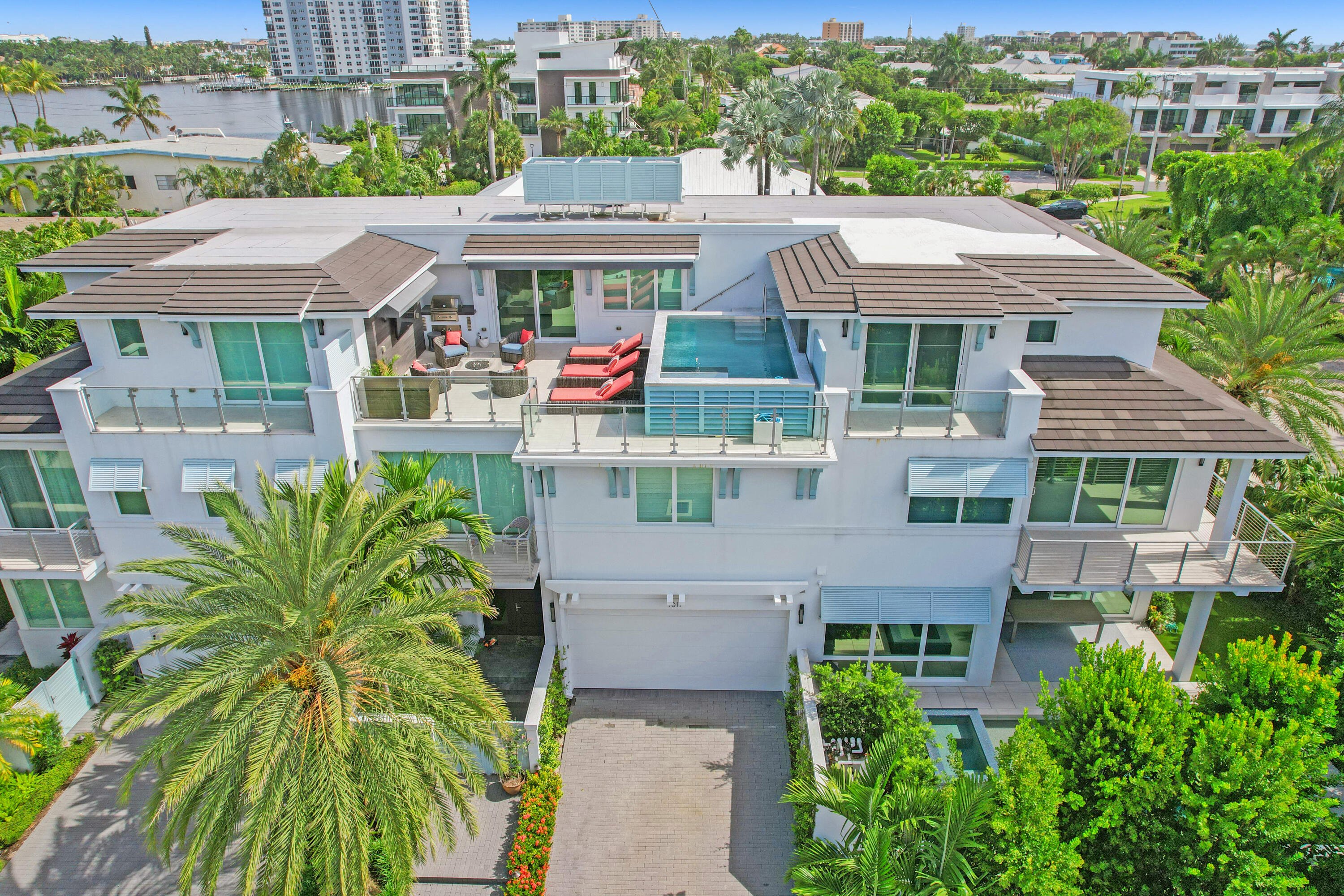 Stunning turn-key, contemporary townhouse in the heart of Delray's sought after Seagate neighborhood. Close to pristine beaches, restaurants and shopping. This gorgeous, property built in 2018 impresses with 4 spacious bedroom suites, a chef's kitchen, a backyard with a summer kitchen, an elevator, 2 wet bars and a morning-bar, a clubroom on the third floor and best of all, an awe-inspiring roof top terrace, complete with summer kitchen, entertainment system and a refreshing private pool. Savour stunning sunsets and waterviews from here. The home is conveniently fitted with Sony surround sound, Control4, water softener systems and more. The spacious, two car garage has extra high ceilings allowing for lifts. No cost or effort was spared in making this the perfect Delray Beach residence.