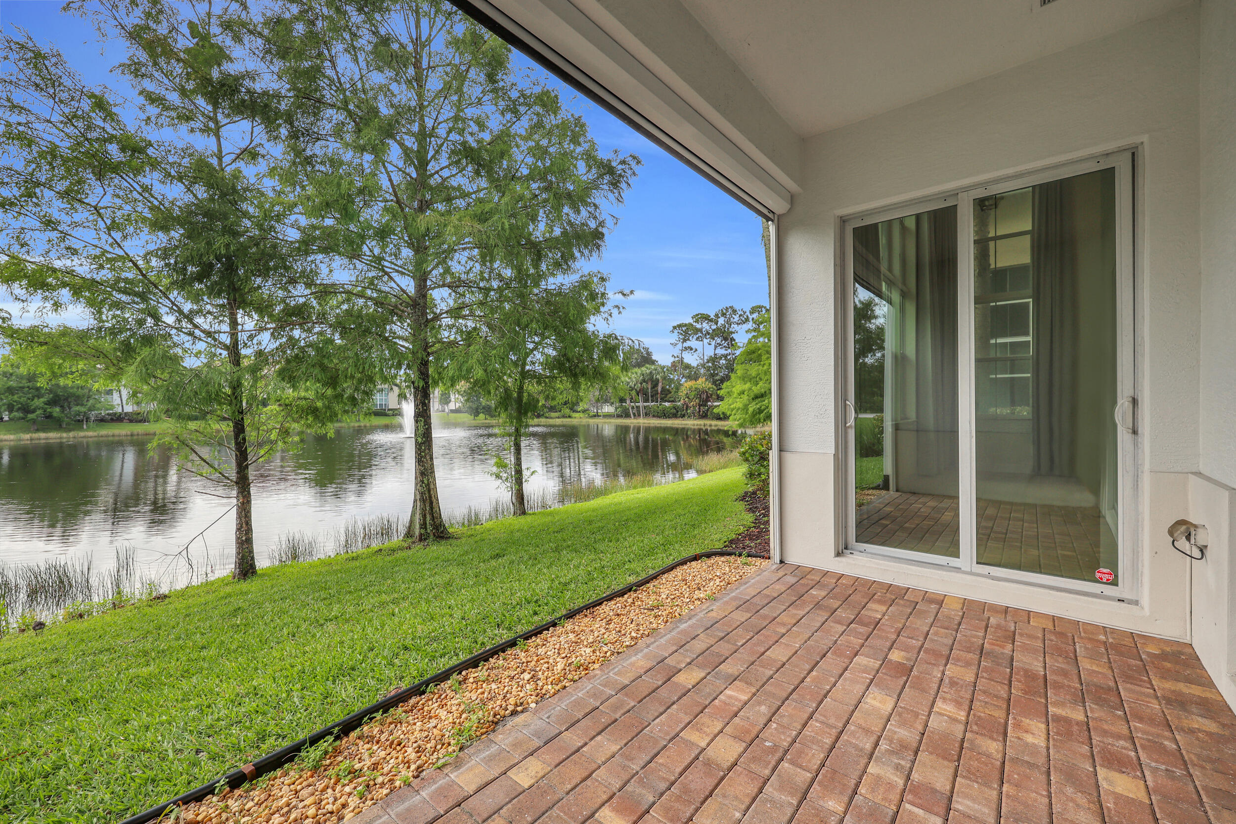 One of the few lakefront residences in Hampton Cay, this meticulously maintained end-unit Calista model offers privacy, upgrades, and flexible living space. With 3 bedrooms, 3.5 bathrooms, a dedicated office, spacious loft, and a 2-car garage, the floor plan accommodates a variety of needs. The first-floor primary suite features a renovated bath with a freestanding tub, walk-in shower with rain head, and updated finishes. The kitchen has been updated and opens to the living and dining areas, while the adjacent office features extensive custom built-ins, creating a turnkey workspace. A modernized staircase with cable railings enhances the home's open feel. New flooring has been installed throughout the primary suite and second level. Upstairs, the loft provides a separate living area suitable for a media room, fitness space, game room, or golf simulator. Two guest bedrooms and two bathrooms, including a fully renovated bath, complete the second level. The screened patio overlooks the lake and is equipped with electric screens. Additional improvements include a new roof, upgraded laundry room cabinetry, impact glass throughout, and an EV charging station in the garage. Hampton Cay offers a gated setting with a clubhouse, fitness center, resort-style pool and spa, and a central Palm Beach Gardens location convenient to shopping, dining, golf, beaches, major highways, and Palm Beach International Airport.