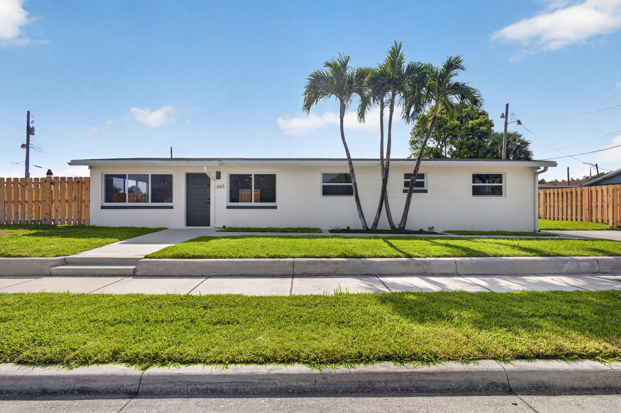 It's like living in a brand new house! Completely renovated 4 bedroom mid-century modern ranch designed home. Solid CBS construction. Everything is new: A/C; complete hurricane impact doors and windows; water heater; all new Samsung appliances including a full sized washer & dryer; huge kitchen boasting 21 soft-close shaker cabinets and drawers; stunning Quartzite breakfast bar; LVP flooring throughout. New completely renovated bathrooms! Fully fenced yard for pets and kids with a new shadowbox fence. One covered paver brick patio facing east, so it enjoys cooler morning sun and is shaded in the afternoon & evening! Another large open patio on the north side of the house for entertainment. New lawn & sprinkler system. 2 blocks from the Port of Palm Beach and Tropical Shipping.  Investors: property is located in an Opportunity Zone.