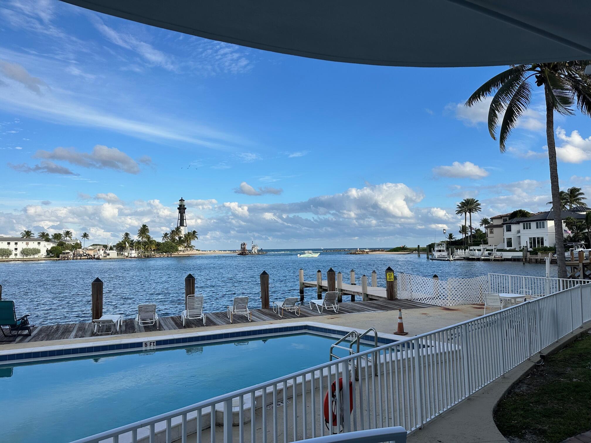Experience exceptional waterfront living  in the prestigious Hillsboro Shores community. This beautifully situated residence offers spectacular views of the Hillsboro Inlet and the iconic Hillsboro Inlet Lighthouse, creating a stunning backdrop from sunrise to sunset. Enjoy watching yachts, sportfishing boats, and sailboats pass by from your own backyard while embracing the tranquility of waterfront living.  Ideally located east of A1A, this unit offers the rare combination of protected waterfront and easy access to the Atlantic Ocean.  Perfect spot for any watersports enthusiast.  Currently used as a 5* short term rental unit.   Perfect for snorkelers on the Wahoo Bay Marine Observatory.  Steps from the Water Taxi pickup.   Restaurants and Marina with in walking distance.