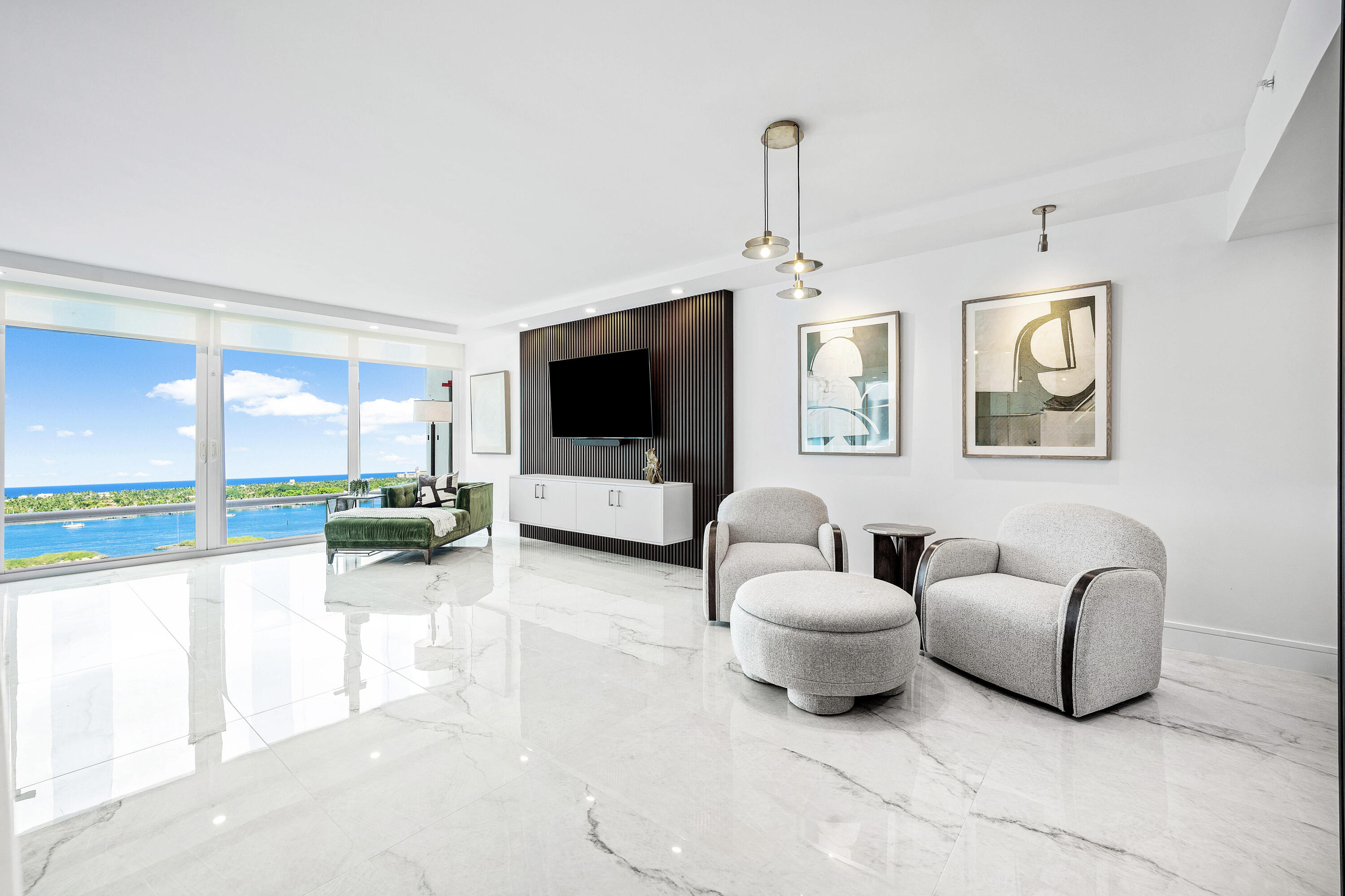 Step into a masterfully redesigned 2,091sqft residence at The Plaza, offering breathtaking ocean, intracoastal, and sunset city views from an ultra-luxury, east-to-west layout. Every inch of this home has been fully-renovated with no detail overlooked, blending modern elegance with thoughtful functionality. A grand, light-filled great room features polished porcelain tile throughout, custom fluted millwork, integrated media wall, and a designer wet bar with illuminated glass cabinetry; all capturing sweeping waterfront vistas through floor-to-ceiling impact glass. Visual Comfort lighting, art spotlights, and sleek architectural lines create an atmosphere that is as refined as it is inviting. The gourmet kitchen showcases Thermador appliances, bespoke cabinetry, backlit display elements, and exceptional storage. The spa-quality bathrooms are beautifully light-filled with windows, and include custom-feature walls, oversized glass showers with rainfall fixtures, luxury vanities, and sophisticated brass accents. The primary suite boasts a show-stopping bath with freestanding tub and skyline views, plus a fully customized boutique-style dressing room with integrated LED lighting and built-in cabinetry. The Plaza is one of West Palm Beach's iconic full-service buildings, offering private gated entry, 24-hour guardhouse and valet, five-star concierge, two pools facing east and west, hot tub, three fitness centers, tennis, pickleball, sauna, steam room and beautifully maintained grounds. The building is currently undergoing an exciting exterior enhancement, with balconies being fully renovated to all-glass railings and a fresh, modernized façade, elevating the overall aesthetic and future value of the property. Enjoy complimentary AKA Hotel amenity passes while building improvements are underway. Unmatched design, craftsmanship, amenities, and panoramic viewsperfectly positioned moments from One Flagler, West Palm Point, 360 Rosemary, and the best of downtown West Palm Beach living. Ideally located moments from the waterfront, dining, and cultural destinations that define this premier urban lifestyle. A rare move-in ready residence offering unmatched design, craftsmanship, and incredible views in the heart of West Palm Beach.