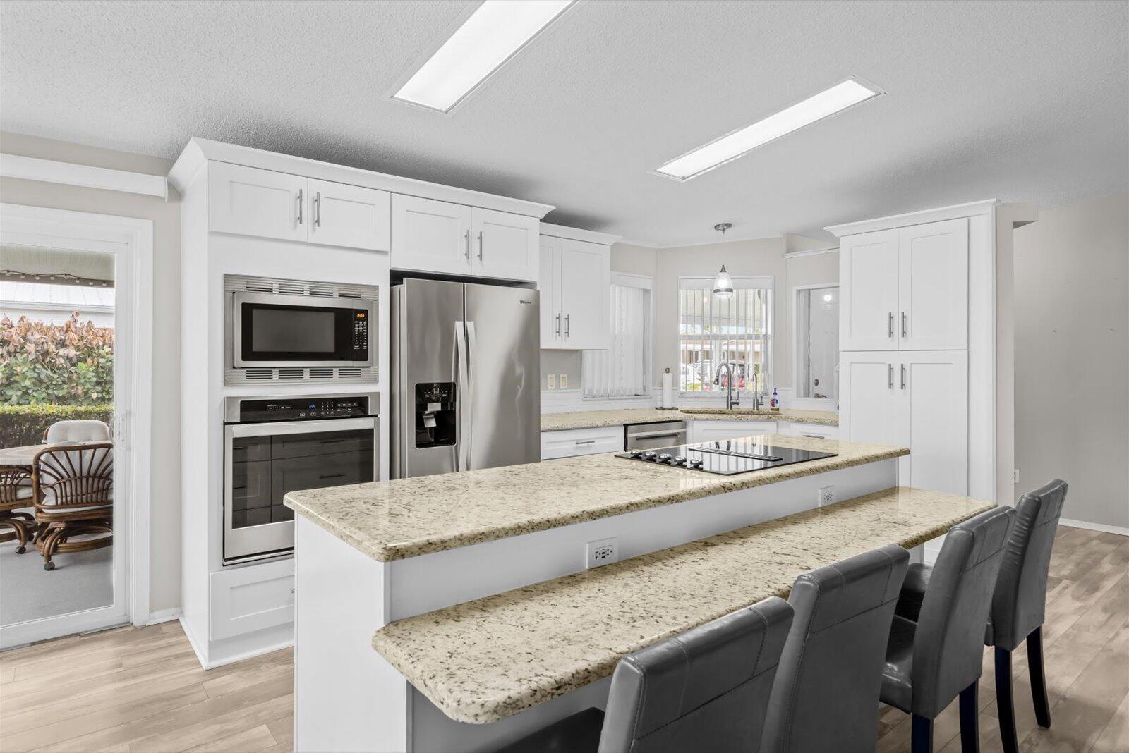 Welcome home to the ever-popular Islander III model, perfectly positioned for the Florida lifestyle you've been dreaming of! Imagine starting your mornings lakeside, enjoying peaceful water views right from your beautifully updated island kitchen featuring gorgeous granite countertops and an open, inviting floor plan. Home offers 2 BR's, 2 BA's plus a versatile den with elegant French doors--ideal as a home office, hobby room, or even a third bedroom for visiting guests. Update features include SS Appliances, 2019 roof, 2023 A/C, 2025 W & D, lam. floors thru/out. Located just a short golf cart ride to the 2 clubhouses, you'll enjoy access to 3 pools, a theatre, on-site restaurant, 18 hole golf course, recreation center, and endless activities in this vibrant 55+ community. Land Lease