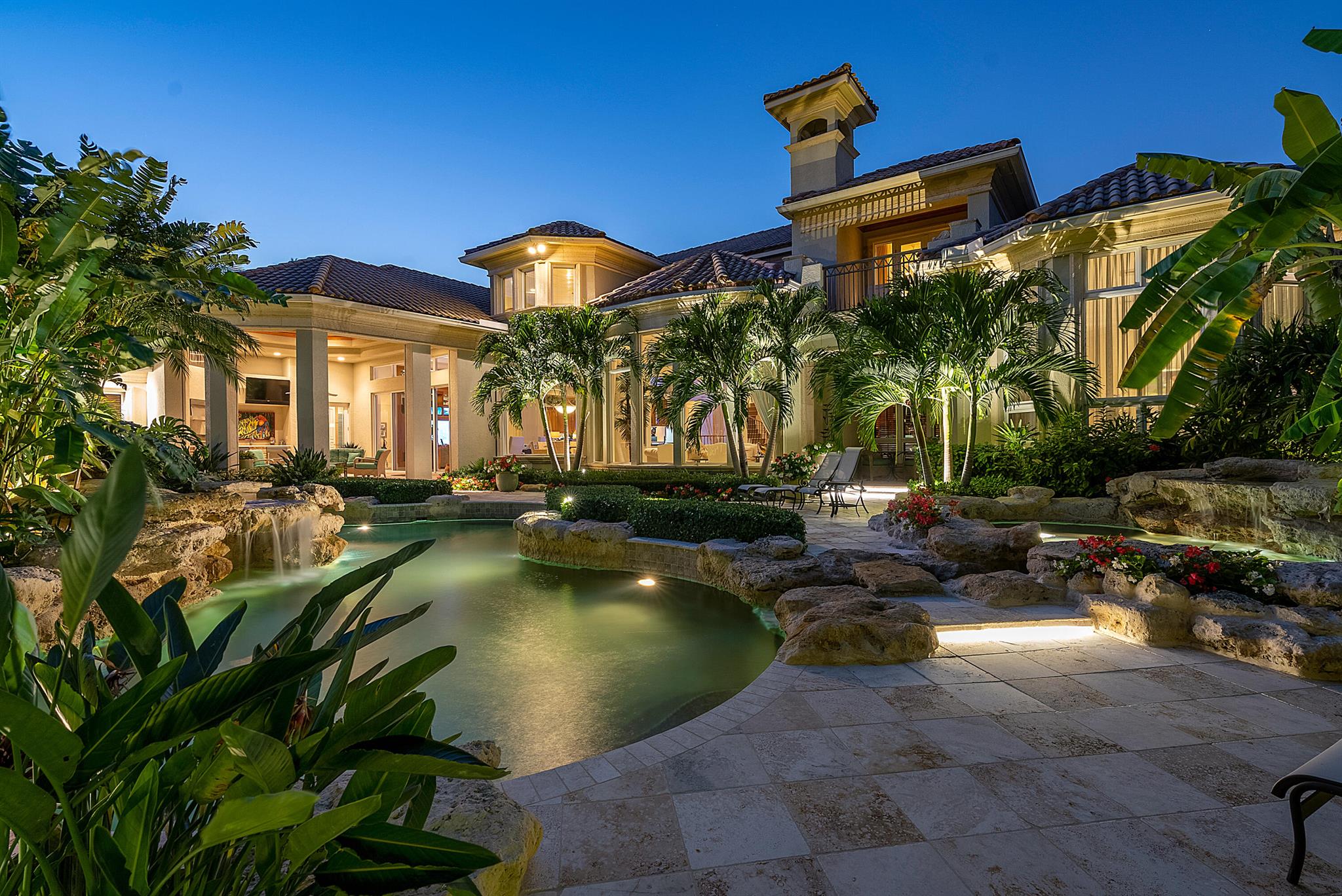 Immerse yourself in the unparalleled beauty of this exceptional waterfront estate, meticulously crafted in the prestigious Royal Palm Yacht & Country Club. With captivating waterway views, this bespoke residence offers a tropical oasis. Sprawling across an expansive 2.25 lots, encompassing over half an acre of lush greenery, and boasting an impressive 216 feet on the Buccaneer Palm Waterway, this architectural marvel designed by Randall Stofft promises an extraordinary living experience.
Indulge in the enchanting ambiance of the meticulously landscaped grounds, where outdoor entertaining is elevated to an art form. Covered terraces invite you to savor the natural surroundings, while the multi-level pool and spa, thoughtfully positioned to embrace the southern exposure, provide the ultima retreat for relaxation.
Inside, curated interiors seamlessly blend with the picturesque backyard, perfectly complementing the open and flowing floor plan. The residence showcases five sumptuous bedroom suites, two offices, and a captivating library, all meticulously designed to meet the highest standards of luxury living.
Experience the epitome of luxury living in this exquisite waterfront estate, where every detail has been thoughtfully curated to provide an unparalleled lifestyle of elegance and refinement.
Buyer to pay documentary stamp taxes on the deed and title insurance. Furniture is negotiable.