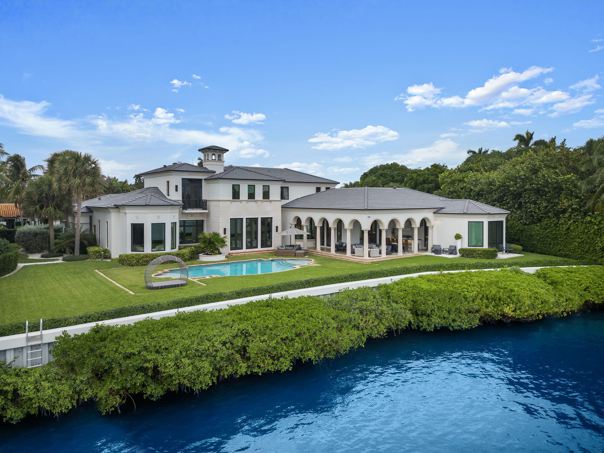 Welcome to this stunning 10,645 total square foot home that was completely renovated in 2023. Located on an over half acre, high elevation, waterfront lot in the prestigious Manalapan, Florida. This luxurious property features a brand new roof, impact doors and windows, multi-zoned air conditioning system, tankless water heater, full house generator, custom cabinetry and closets, top of the line finishes and so much more! As you step inside, you will immediately be captivated by the grandeur of this residence. With 6 bedrooms, 8 full baths, and 2 half baths, this home is designed with ample space and comfort. The first floor features a primary suite with his and her en suite bathrooms, oversized walk-in closets, home office and sitting room overlooking the water. Another separate, first floor bedroom with a full bath and closet would make the perfect ''in-law,'' nanny, or guest suite.
Upstairs, you will find 4 additional bedrooms, each with en suite baths and walk-in closets, offering complete privacy from the primary suite.

The interior boasts soaring ceilings and natural light throughout with exquisite custom features like the a Dominican coral fireplace, pecky cypress beamed ceilings, LED lighting accents throughout, and a custom kitchen with top-of-the-line appliances including a Miele coffee bar, Sub-Zero refrigerator, a Wolf gas range with double ovens and a separate scullery kitchen great for catering dinner parties! The club room with a full bar and wine room adds a touch of sophistication, and is perfect for entertaining guests.

Outside, the property offers over 170 feet of direct water frontage, allowing for breathtaking views of the intracoastal and amazing fishing right in your backyard. Approved plans for a deepwater dock with lift, and a pool house are included. The outdoor space is designed for relaxation and entertainment, featuring a pool, outdoor covered loggia, and an outdoor kitchen. With new hurricane impact windows, doors and roof, you can enjoy peace of mind during storm seasons.

The location of this home is truly exceptional, with gated security provided by the Manalapan police and deeded membership to the Eau Spa private beach club just a golf cart ride away. Enjoy spectacular sunrises over the water or a boat ride along the intracoastal with ocean access minutes away. All of this coupled with the convenience of being in close proximity to world class dining and shopping in Palm Beach and downtown West Palm Beach, make this home like no other.

Don't miss the opportunity to experience the epitome of luxury living in this remarkable Manalapan waterfront residence. Schedule your private tour today and indulge in the waterfront lifestyle you've been dreaming of.