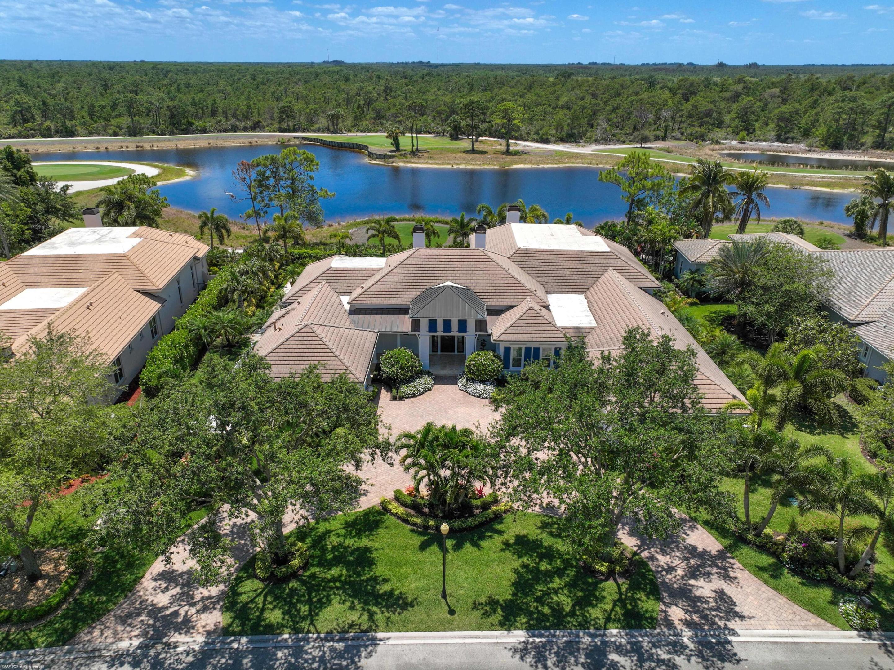 Enter through the beautiful guarded gates to see this magnificent 4B/6.5B Estate Section home on Medalist Place with spectacular lake and golf course views.  Vaulted ceilings with custom moldings, marble, hardwood and tile flooring, large outside  lanai with fireplace, remote phantom screens and summer kitchen. Custom built library/office (could be  a 5th bedroom). Resort style pool with gas heated spa, whole house propane generator, three car garage, fully fenced in backyard with lush tropical landscaping. New impact windows & doors, new roof & gutters 11/2024. Freshly painted inside & out. Other features are wet bar, wine cellar,  new 6 burner gas stove, well water irrigation system.  minutes from shopping, restaurants and ocean beaches. Club house with restaurant, tennis & golf. Recent Improvements: Two new Propane Gas On Demand Insta-Hot Tankless Water Heaters. All new Hurricane Impact Windows & Doors. New High End Kitchen Appliances, New Wood Floor in Office. New Loggia Phantom Brand Remote Control Retractable Screens. Flo by Moen Emergency Water Shut Off System. Freshly Painted Interior & Exterior. New Propane Gas Pool & Spa Heater.   New HVAC. Please Note: Waterford Crystal Chandelier in Front Foyer Does Not Convey.