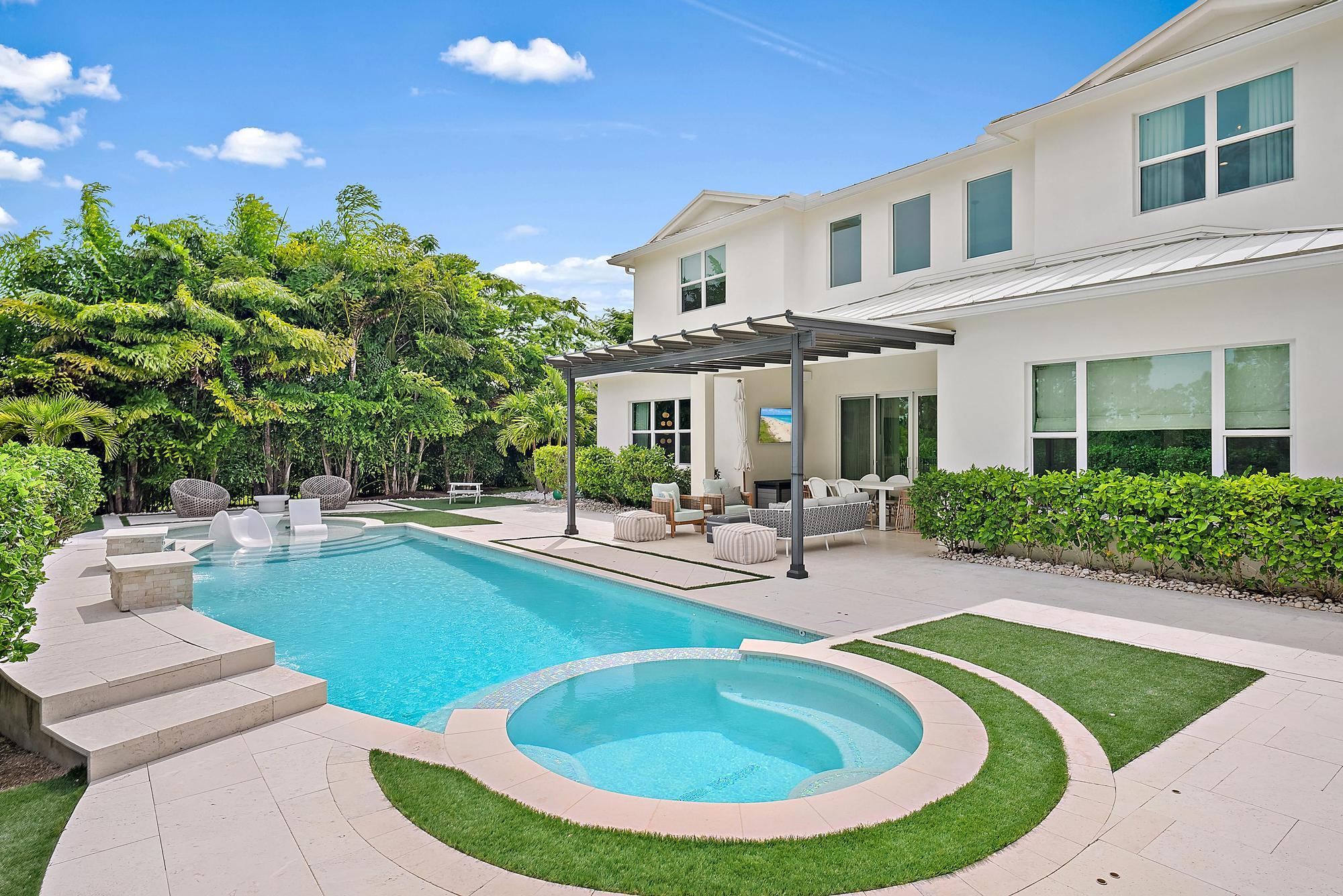 ABSOLUTELY HIDDEN GEM! Nestled on a 1/2 ACRE private PRESERVE lot in the highly sought-after gated community of Prado in Jupiter, this beautiful coastal designed 2020 CBS home; offers the perfect blend of elegance, comfort, and modern amenities. Boasting 5 spacious bedrooms plus a versatile loft & den, 4.5 designer bathrooms, & a 3-car garage, this residence is thoughtfully crafted to suit the needs of today's discerning homeowner.
Step outside into your personal oasis—an entertainer's dream featuring complete landscaped privacy, a custom pool with sun shelf, relaxing hot tub, & turf area with a private putting green & chimenea perfect for gatherings. The fully fenced backyard offers peace of mind while providing ample space for family fun & outdoor living. Inside, enjoy high-end finishes including open concept living areas illuminated by high end custom fixtures, designer custom window treatments, stunning custom millwork throughout including oakwood ceiling in entrance foyer, custom finished mud room plus multiple custom-built ins throughout the home, soaring ceilings and abundant natural light. The house offers a whole house GENERAC generator 24KW & a gas line ready to be connected for your future outdoor summer kitchen. Every detail has been curated with style and function in mind, making this home as beautiful as it is livable. The main living areas offer wood plank tile floors, the kitchen is a chef's dream including high end monogram appliances (including gas stove), quartz countertops, backsplash, white maple wood cabinetry with extended kitchen cabinetry perfect for all of your storage needs, a large kitchen island ideal to entertain family & guests. The extended main bedroom is located on the lower level with a luxurious bath, freestanding tub & generously sized walk-in closet. Experience luxury living in a serene natural setting, all within minutes of Jupiter's top-rated schools, pristine beaches, golf courses, and vibrant dining and shopping destinations.