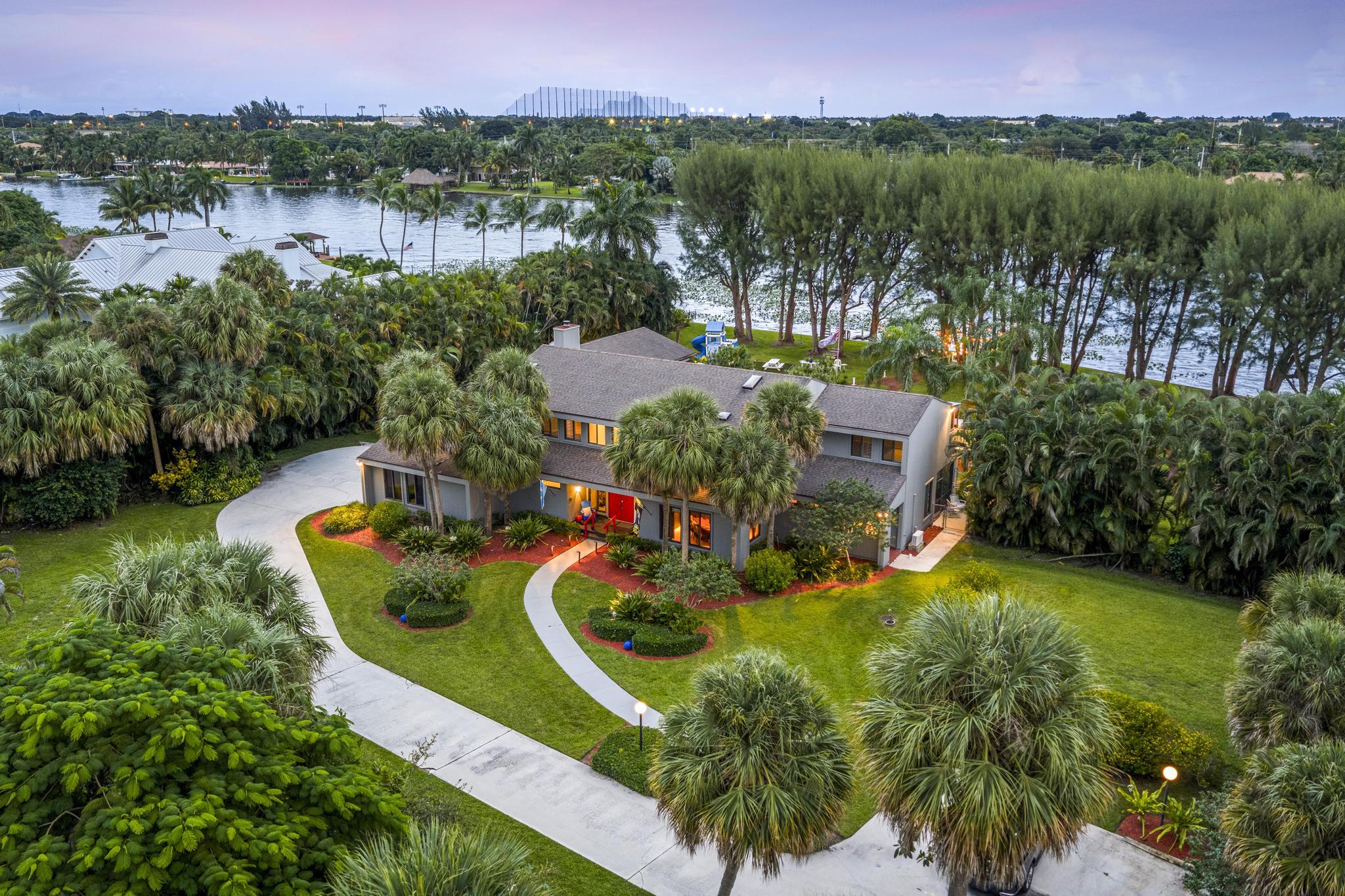Introducing an unprecedented offering in Lake Clarke Shores, a once-in-a-lifetime opportunity to own an estate set on three combined lots totaling 1.7 acres (74,052 SqFt) with the largest freshwater lake frontage in Lake Clarke Shores. Surrounded by mature vegetation and expansive water views, this residence offers the ultimate in privacy, seclusion, and lifestyle. With miles of navigable boating to the north and south, plus a private dock and seawall, the property provides unmatched access to one of South Florida's most unique freshwater waterways. At the heart of the estate stands a 6,054 Total SqFt traditional home, designed with timeless craftsmanship and modern functionality. Inside, you will find 6 bedrooms and 4.5 bathrooms, high ceilings, and dramatic living spaces with panoramic lake views from nearly every room. Highlights include a grand foyer with over 17-foot ceilings; a living room and formal dining room with tray ceilings; a family room with 8-foot sliding pocket doors, plantation shutters, a fireplace; and a chef's kitchen featuring granite countertops, double sinks, Sub-Zero refrigerator, double oven, gas stove, and cabinets with plenty of storage space. The main level also includes a primary suite option with private exterior access, ideal for an in-law suite.
Upstairs, the second primary suite offers vaulted ceilings, dual closets, and sliding doors that open to a private deck with stunning lake views and a beautiful spiral staircase that leads to the breathtaking backyard. The luxurious en-suite bath features a soaking tub, a large shower with dual shower heads, and double vanities. The residence also features 4 spacious bedrooms upstairs, 3 of which boast direct water views. For added convenience, the laundry room, complete with a wash tub, is located upstairs.
The outdoor living is equally impressive, with a screened patio running the length of the home, an expansive backyard with an oversized pool, and plenty of space for kids to play, to entertain, to garden, and so much more.
Adding to the estate's versatility is an air-conditioned guesthouse totaling 961 SqFt, complete with its own kitchen, full bath, walk-in closet, laundry room, covered patio, outdoor shower, and water views. It is ideal as a guest retreat, game room, private studio, pool house, or man cave.
Set within the exclusive Lake Clarke Shores community, residents enjoy the charm of a small-town atmosphere, a private police department, an active multigenerational lifestyle, and an unbeatable location just minutes from the Island of Palm Beach, pristine beaches, the Intracoastal waterway, downtown West Palm Beach, and premier shopping, dining, and schools.
A property of this caliber, never before listed, is more than a home; it is a legacy estate and a rare opportunity to own one of the most exceptional pieces of real estate in Palm Beach County.