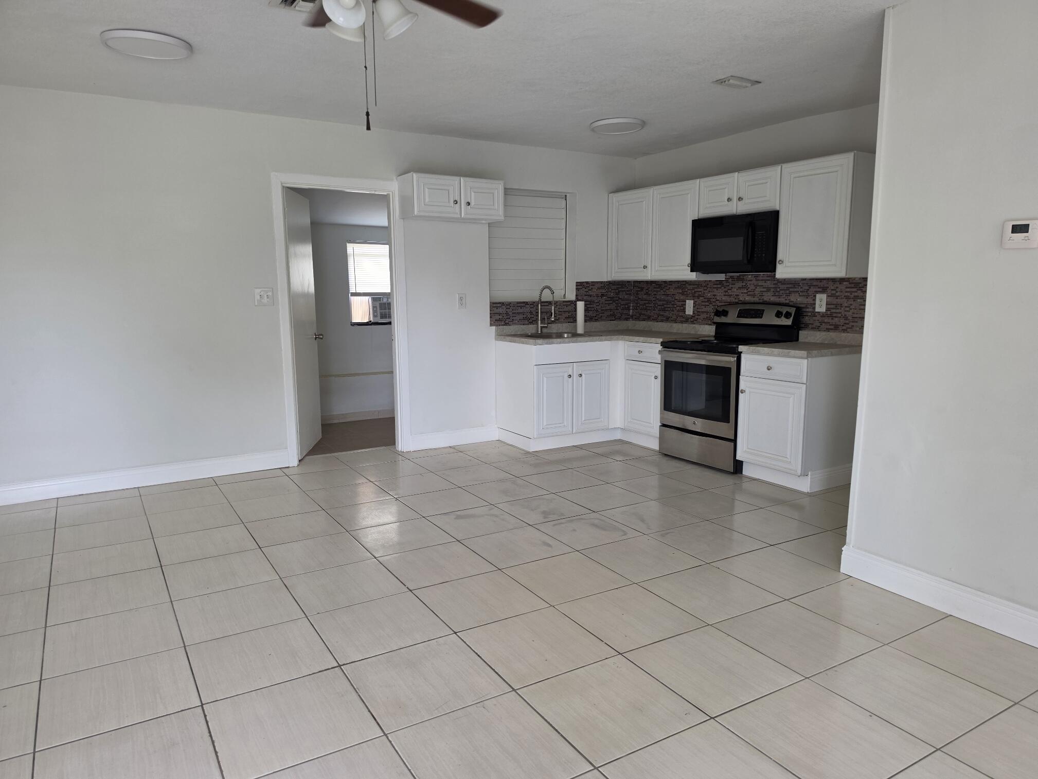 Welcome to this beautifully renovated 3-bedroom, 1-bath home with extra enclosed patio, laundry room and 2 car carport .   Step inside to discover a bright, open living space featuring fresh interior finishes, updated flooring, and a beautifully remodeled kitchen and a new ac system. The renovated bathroom offers contemporary fixtures and stylish finishes, while the spacious bedrooms provide comfort and flexibility for family, guests, or a home office.  Outside, enjoy a generous yard with plenty of room for entertaining, gardening, or future additions. Conveniently located near beaches, parks, schools, shopping, dining, major highways, and the Port of Palm Beach.