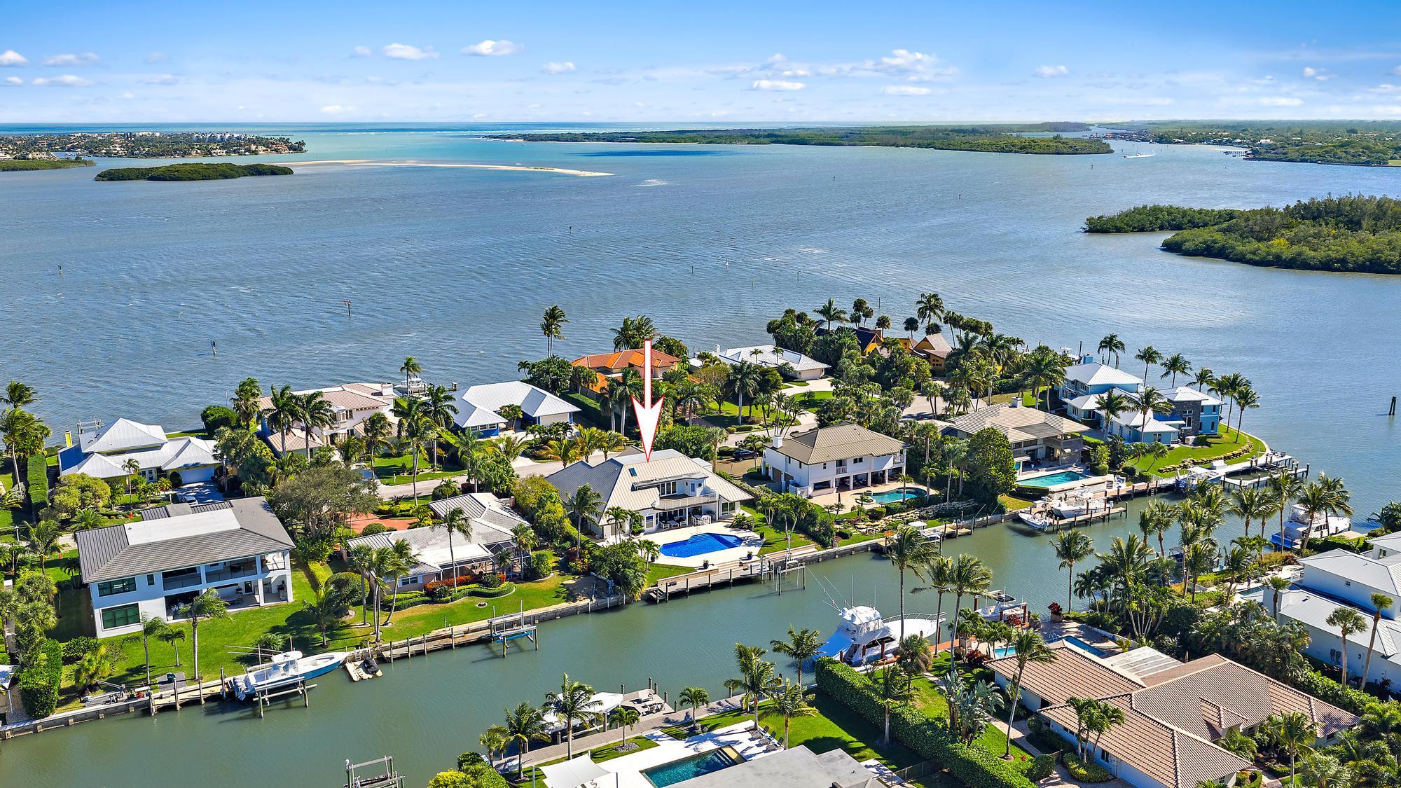 One-of-a-kind waterfront residence in the exclusive High Point Island enclave off Sewall's Point, set along a rare blue-water canal with deep-water access, completely rebuilt in 2024 to the highest standards and professionally designed. The well planned layout includes 4 spacious bedrooms, 4 1/2 baths, a den/office and the rare convenience of laundry rooms on both the main and upper levels. The gourmet kitchen features custom inset cabinetry, an impressive 10 1/2 foot island, and professional-grade Thermador appliances with a Sub-Zero refrigerator, ideal for both everyday living and entertaining. The primary suite is a private retreat offering a balcony, dual walk-in closets, a separate water closet, a soaking tub, and an oversized spa-style shower. Outdoor living is exceptional, with a custom heated pool and sun shelf, covered patio, a new 55 foot dock, 100 feet of water frontage, two boat lifts, and no fixed bridges, offering effortless access for larger vessels. Additional highlights include a 2021 metal roof, 2025 impact glass, whole-house generator, EV-ready garage, circular driveway, ample storage, and an oversized air conditioned garage with 12 foot ceilings and 30 foot depth ideal for an RV, car lift, or specialty vehicles. A rare opportunity to own a fully customized waterfront residence in one of the Treasure Coast's most desirable island communities.