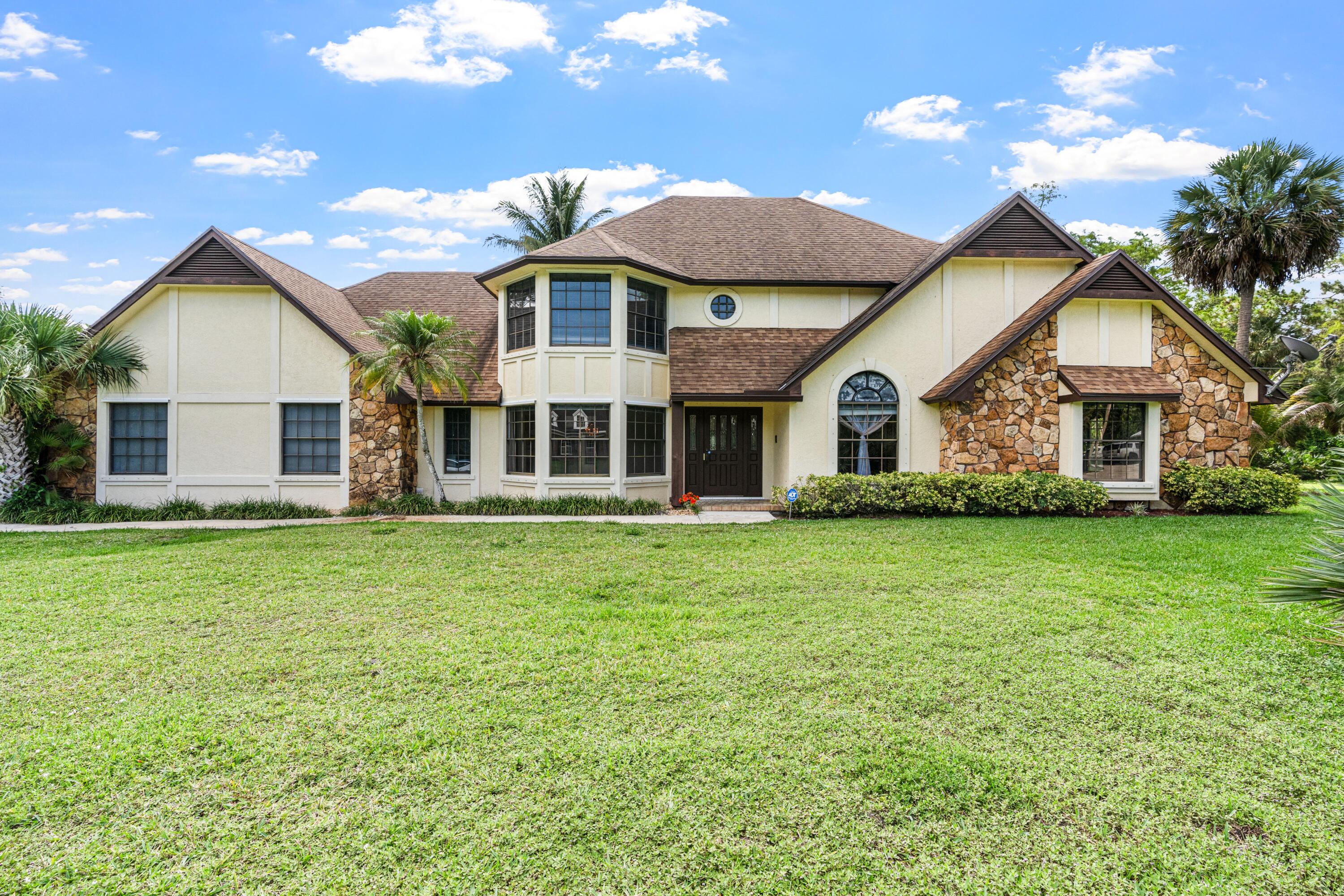 Rare opportunity to own an incredible 1-acre estate with an unmatched 8-car detached garage plus an attached 2 car garage - totaling a 10-car garage capacity, located just minutes from Wellington's premier equestrian venues and top-rated schools! This spacious 4BR/3BA single-family home features an open, inviting layout with ample room for customization. Step outside to a massive, cleared backyard offering a completely blank canvas; there is plenty of room to design your ultimate backyard paradise, plus space left over. Best of all, a low HOA allows you the absolute freedom to store your boat, RV, or commercial vehicles. Combining the peace of country acreage with the convenience of suburban living, this property is a rare find in today's market.  All information pertaining to the property is deemed reliable, but not guaranteed. Information to be verified by the Buyer. Be advised that cameras may exist recording audio and video inside/outside the property, such as ring doorbells. Photos are digitally enhanced and could be altered, please verify.