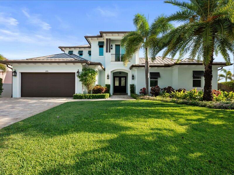 Come see this exceptional custom-designed West Indies inspired waterfront estate, where sophisticated design, understated luxury, and the ultimate South Florida boating lifestyle come together in seamless harmony. Completed in 2018, this five-bedroom plus office, four-bath waterfront residence with a two-car garage presents a rare offering of modern construction and refined Florida living - just moments from the Jupiter Inlet with no fixed bridges.  Bring your boat and embrace the ultimate waterfront experience. With 100 feet of water frontage, a 40-foot private dock, 16,000-pound lift, and a rare private boat ramp, this property is a dream for boating enthusiasts. Whether it's a sunrise cruise or a day of offshore fishing, you're on open water in minutes. Step through the front door and  and prepare to be captivated. A grand foyer reveals sweeping water views, while walls of hurricane-impact glass flood the home with natural light. The open-concept design creates a seamless flow between living spaces, all oriented to maximize the stunning waterfront and every room enjoys a view. At the heart of the home, the gourmet chef's kitchen is both striking and highly functional. Featuring a 48-inch Sub-Zero refrigerator, Wolf induction range with convection oven, Wolf steam oven, Bosch dishwasher, and a spacious center island, it's designed for both everyday living and entertaining at scale. A walk-in pantry with electrical, reverse osmosis water system, and a dedicated wine bar with beverage cooler elevate the experience even further. The main level lives like a luxurious single-story residence, offering wide, open spaces and full accessibility. The owner's suite is a private sanctuary that is light-filled and serene with a custom walk-in closet and a spa-inspired bath complete with dual vanities, soaking tub, and walk-in shower. A second bedroom, full cabana bath with direct pool access, and a private waterfront office provide flexibility for guests or working from home. Upstairs, the home continues to impress. A dramatic loft with big-screen TV viewing area and a second wine bar opens to an expansive balcony that is perfect for morning coffee or evening cocktails with panoramic water views, including glimpses of the iconic Jupiter Lighthouse. Three additional guest bedrooms, each with private balconies and water views, along with two full baths, create an inviting and private retreat for family and visitors. Outside, your personal resort awaits. The custom heated saltwater pool and spa, complete with sun shelf and umbrella, invite endless relaxation under the Florida sun. Entertain with ease on the covered patio or unwind in the generous 50-foot waterfront side yard. With AquaLink smart controls and a Jandy heat pump, every detail is designed for comfort and convenience. Additional features include whole-house RainSoft water filtration, tankless hot water heater, plantation shutters, custom closets throughout, and a well appointed laundry room with utility sink and extra storage. Perfectly positioned in an in-town Jupiter location, you're just moments from pristine beaches, waterfront dining, golf, world-class shopping, and only approximately 20 minutes to Palm Beach International Airport. Walk to local restaurants, enjoy nearby marinas, or spend the day at the beach - this location truly has it all. This is more than a home, it's a statement, a sanctuary, and a lifestyle. Whether you're seeking a full-time residence or a seasonal escape, you will feel like you're on vacation every single day. Schedule your private showing today and experience one of Jupiter's finest waterfront offerings. We guarantee private showings with buffered exclusivity.