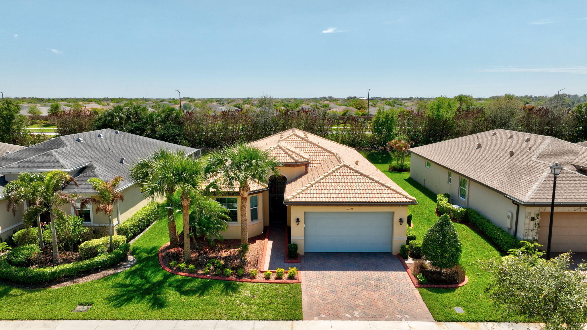 SELLER OFFERING $10,000 towards buyer's closing costs, pre-paids, or non-allowables.  This 3bd/2bth home located in the 55+ active adult community of Lake Park, Tradition.  The owners have spared no expense in upgrades.  Concrete tiled roof; wired for a generator; hurricane impact windows and doors; tiled throughout; camera system; Surge protection for the whole house;  2021 Goodman HVAC unit with centralized Humidistat, Air purification system which reduces air pollutants,odors, VOCs, smoke, mold bacteria viruses, A/C Germicidal System - helps disinfect  A/C cooling coil, drain pan, internal surfaces of HVAC system, it also improves indoor quality.  Crown Molding throughout including windows and doors, except the closets; Tankless water heater; Ecowater water conditioner digital system. Many more upgrades including stainless steel appliances; 42' maple cabinets; island kitchen with rounded edge granite countertops; Formal dining room; breakfast nook;   High tray ceilings in the master; Recess and upgraded lighting; His and Her closet, sinks and pocket door in the mastersuite, that features a bay window and stain glassed windows in both bathrooms; Lorex Security System with outdoor and indoor camera in garage and living room; Ceiling Fans in all rooms and on the patio; Crystal Chandelier in foyer;  Closet and sink with cabinets in laundry room; Brick paver driveway with extended brick paver back patio.