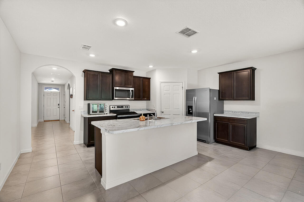 Amazing Opportunity in Celebration Pointe! Your dream home awaits in this 2022-built concrete block residence, with 4 bedrooms, 2 bathrooms and a 2 car garage. This home backs up to serene greenery which offers privacy and tranquility. The split floor plan ensures everyone has their personal space, while the expansive great room is perfect for bringing everyone together. What truly sets this property apart are the incredible amenities paired with low HOA dues. Enjoy access to a refreshing pool, playground, dog park, individual lawn care and so much more!