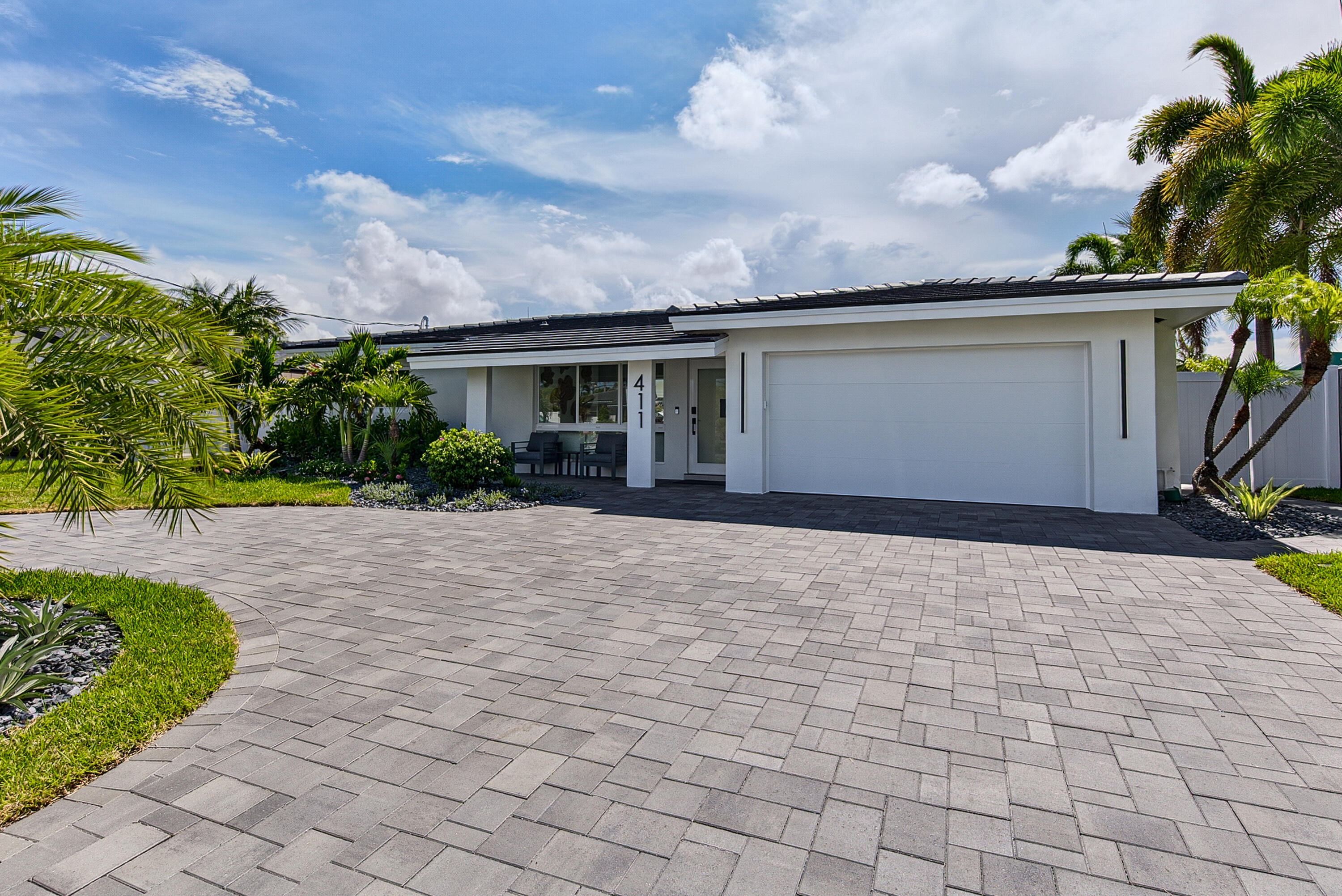 The newest gem of Garden Isles! This stunning, waterfront pool home was masterfully renovated in 2026, offering the pristine feel of new construction. All new concrete tile roof, impact windows/doors, plumbing, electrical, tankless water heater and AC ductwork. Modern kitchen with custom cabinetry, white quartz counters, Samsung Bespoke appliances and Frigidaire Professional gas range. Stunning Coastal Mist porcelain tile floors throughout, floor to ceiling Bianco Onice tile in bathrooms, brushed gold fixtures, raised ceilings, electric fireplace, custom closets, electric shades and smart lighting. Outside: a 60' dock on 70' of seawall, refinished pool, travertine decking, lush turf, and a new paver driveway with a 2-car garage. Your South Florida Waterfront Living, Elevated!