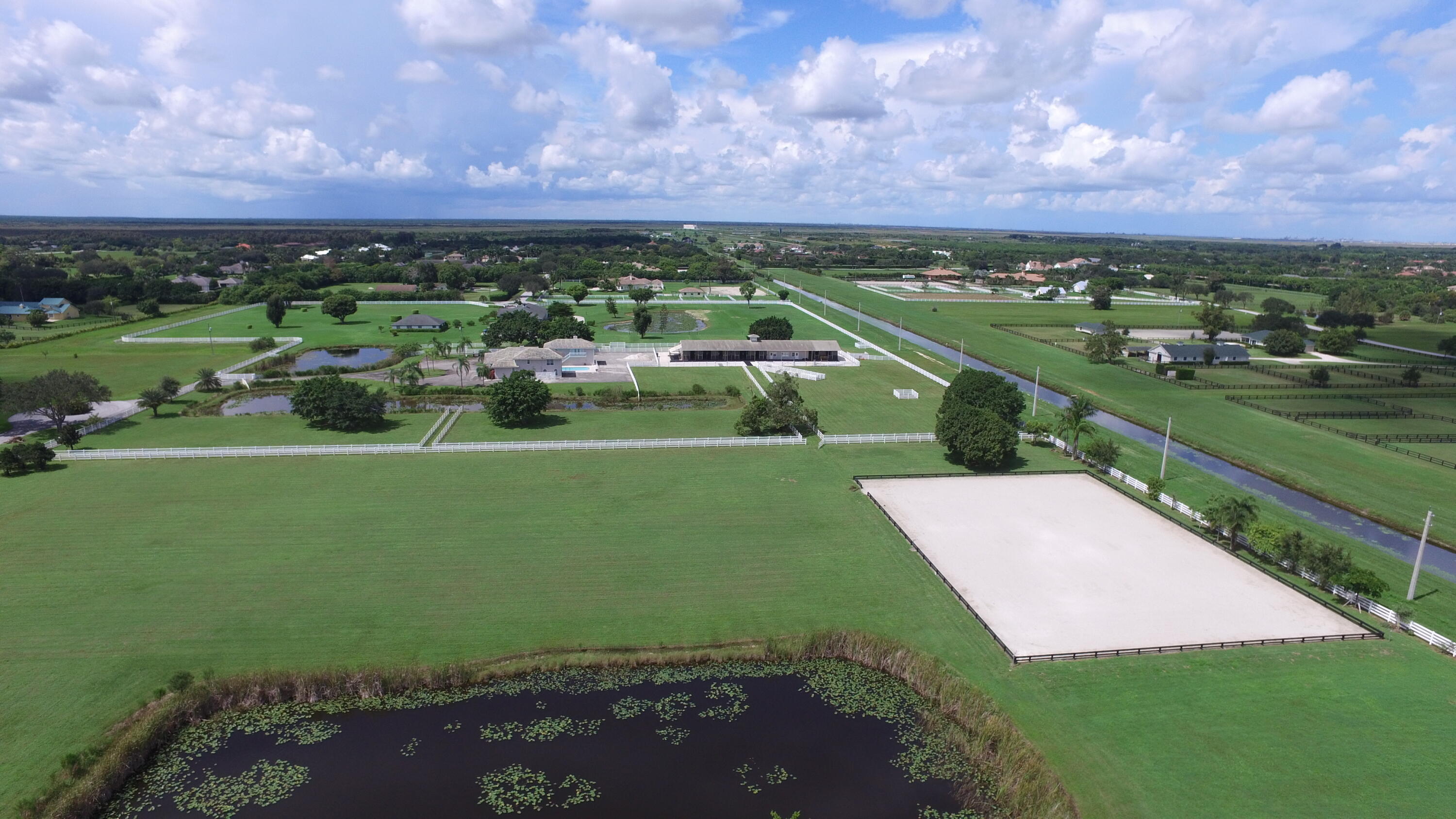 Rare opportunity to own 20 acres in Wellington private equestrian neighborhood. Existing 4,763 SqFt home featuring 6 bedrooms and 5.5 bathrooms. The lots offer plenty of cleared vacant land ready to be transformed into a luxurious equestrian facility. The property is located on the bridle path that connects Palm Beach Point and Grand Prix Village. Convenient access to hacking trails and within walking distance to Wellington International show grounds. 
Palm Beach Point is a gated equestrian community that many of the worlds best equine athletes call home for the winter season. The neighborhood features miles of grass exercise trails and is a short hack or golf cart ride to the equestrian show grounds. Please note 20 acres is split over two adjoining lots jointly on offer; 15255 Estancia at 15 acres and 15101 Estancia at 5 acres.
