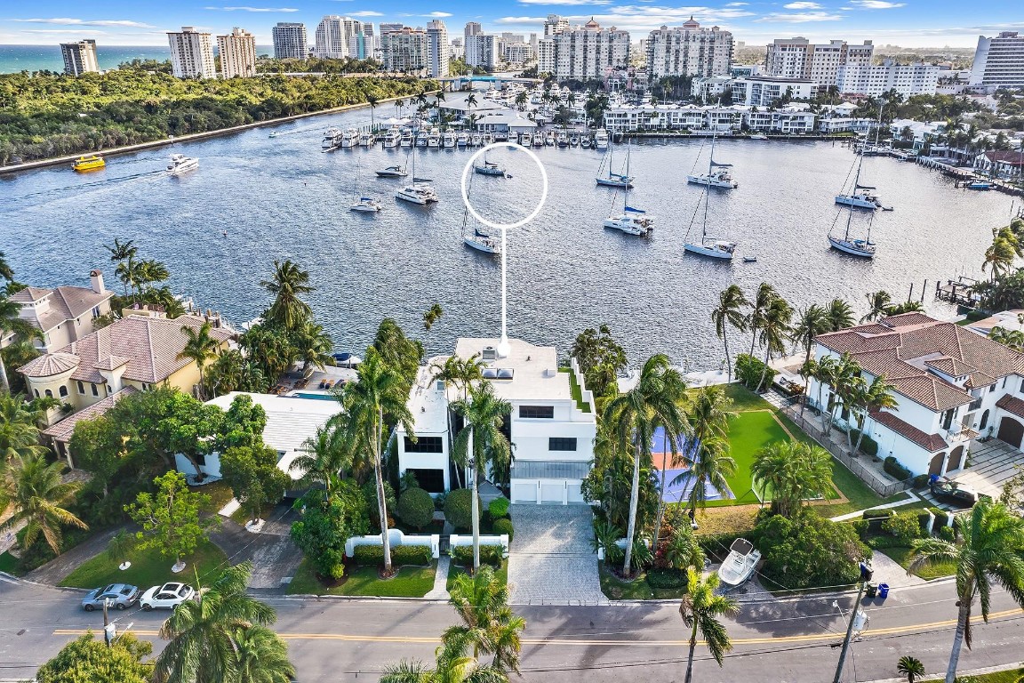 Unrivaled contemporary architecture situated on 80' of waterfront with panoramic views over Sunrise Bay & the Intracoastal waterway. Every element has been designed to cultivate today's modern lifestyle & open concept living. The luminous floor plan is enhanced by 2 story walls of glass & glass railings. The culinary kitchen is ideal for entertaining & over looks the dining area, great rm & luxurious wet bar. The 2 story primary suite has a pvt staircase accessing the 3rd floor office/flex space & roof top terr. The spa inspired primary bathrm features a steam shower, soaking tub & Toto Neorest toilet. The waterside tropical backyard features a covered loggia, fire pit, summer kitchen, heated salt water pool, oversized dock & boat lift. Sq. ft. based on direct measurements from appraiser.