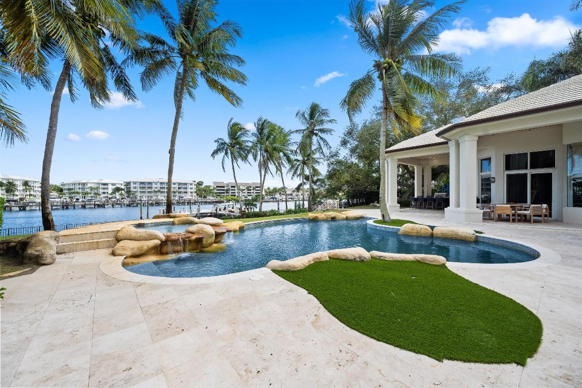 A rare opportunity to own a direct intracoastal estate in the heart of Palm Beach Gardens. Set on a privately gated, elevated 1.04-acre lot with 180 feet of deep-water frontage, this recently reimagined residence was renovated by Caitlin Kah Interiors and offers a true new-construction feel. Surrounded by mature oak trees and lush views, the home enjoys ideal eastern exposure and cooling intracoastal breezes. Interior features include white oak floors, soaring 25-foot ceilings, custom cabinetry, and a chef's kitchen with Wolf, Sub-Zero, and Miele appliances. The resort-style backyard offers a pool and spa, summer kitchen, covered outdoor living areas, and ample space for future expansion.