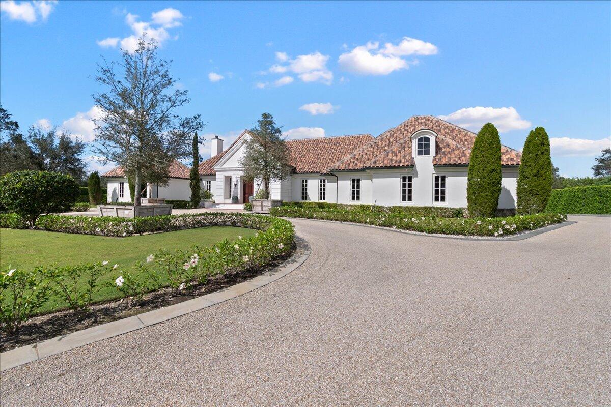 When entering 15495 Sunnyland Lane, one will find the owner's approach to balancing architecture, art and decor. Seldom does an offering with all these components come your way.  The property takes its cues from old-world Europe with manicured plantings balanced in form and rooted in beauty with imported ''flamed'' bluestone through-out the property with pool and living areas that rival any public space. This 6 BR / 5 BA Equestrian Estate is comprised of proportioned rooms, the highest quality hardware, standing and running trim, backdropped with polished venetian plaster walls, Farrow & Ball color hues, reclaimed timbers, highest quality cast stone, custom case goods and cabinetry throughout, custom flooring, hand-made architectural tile, Ludowici thigh-tile roof, professional lighting plan with all custom fixtures, butlers pantry-bar area, halfmoon banquette off kitchen with day lounge, 4 BR, en suite bath for each, The nave of the home has an open floor plan for living and receiving guests. A chef's high performance kitchen boasts a stainless steel professional Wolf station kit, the highest standard without need for ansul fire suppression with handsome custom ventilation hood, backslash water supply and integrated sub-zero refrigeration system. Custom windows and doors with the highest quality glazing make for a quiet experience in every room. 3-car garage. The state-of-the-art cast stone 12+ stall barn is a mirror reflection of the home decor, separate gated entrance with quartyard, Grand Prix ring, jump and trailer storage, utility vehicle building, 3-outdoor/2-indoor wash stalls, 2 grooming stalls, laundry/eating area, feedroom, bathroom, tack/study, owner lounge and office, cobblestone flooring, highest fit and finish for horses and/or concourse car collection. The 2-addition soundproof guest rooms are above the barn. Enter through a second-level veranda overlooking the Grand Prix ring and commanding views.