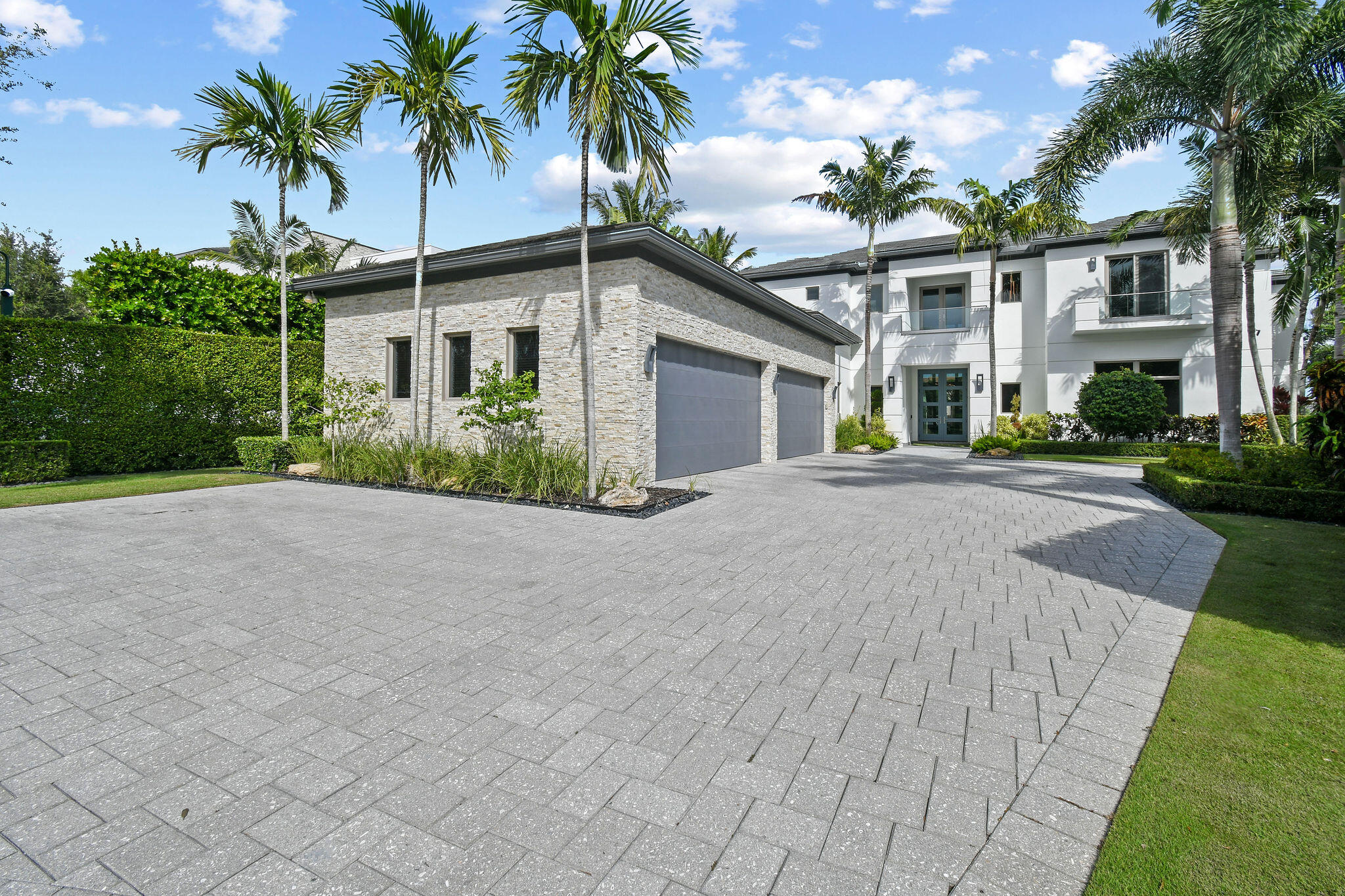 Introducing a beautifully crafted modern waterfront residence located directly on the Intracoastal Waterway in the private, gated community of Harbor Place, adjacent to The Bear's Club in Palm Beach Gardens. Designed and built by Couture Lifestyles in collaboration with Smith & Moore Architects and Pauline Hartogh of Wetherlys Interiors, this custom home blends clean architectural lines with refined finishes and thoughtful functionality.    With 157 feet of direct Intracoastal frontage, the property is ideally positioned to capture expansive water views and natural privacy overlooking the Juno Preserve. Offering nearly 10,000 total square feet, this six-bedroom residence is designed for comfortable everyday living as well as effortless entertaining. The main living areas feature open-concept spaces, floor-to-ceiling glass, and a striking 24-foot linear fireplace that anchors the great room. The chef's kitchen is both stylish and highly functional, complete with dual oversized islands, Downsview cabinetry, quartz countertops, a prep kitchen, butler's pantry, and a full suite of Thermador appliances.   The first-floor primary suite offers serene water views, generous closet space, and a well-appointed en-suite bath. Upstairs, a second primary wing provides a private retreat with its own sitting area, covered balcony, morning bar, custom walk-in closets, and a spacious spa-style bath. Three additional guest suites on the second level each include walk-in closets and designer bathrooms.   Constructed with reinforced CBS tie-beam construction, the home also features impact glass windows and 10-foot sliders, elevator access, electric blinds, marble flooring, designer finishes, whole-house generator, security system, and full smart-home automation. Laundry rooms on both levels and abundant storage add to the home's practicality.   Outdoor living is equally impressive, with a covered loggia overlooking the heated pool and spa, summer kitchen, cabana bath, and outdoor shower. A private beach area, long dock with a 16,000-pound boat lift, and generous waterfront seating complete the boating experience. Private easement from the property to the marina next door, large boat slips available. Conveniently located near the PGA corridor, residents enjoy close proximity to premier shopping, dining, golf, and the beaches of Juno and Jupiter, as well as easy access to the Jupiter and Palm Beach Inlets.   A thoughtfully designed waterfront home offering quality craftsmanship, modern comfort, and exceptional Intracoastal living.