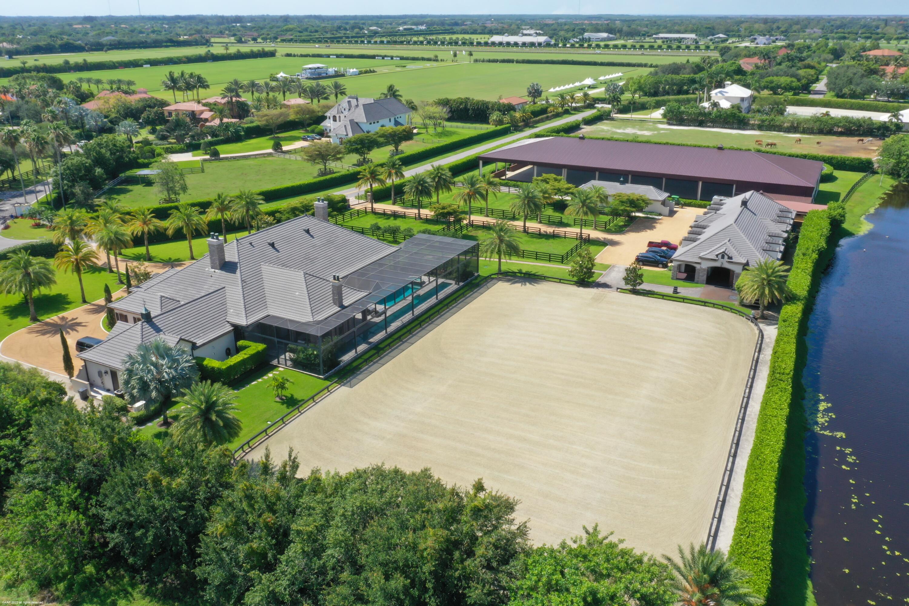 One of a kind equestrian estate on 5.54 acres with covered & outdoor riding arenas & a 17 stall center-aisle barn! Situated in a prime location close to GDF & WEF, this property was designed for top equestrians. The 4Br main residence boasts: stone floors, a center-island kitchen w/gas cooking, wine cooler, walk-in pantry, impact window & doors, a stunning heated pool with lap lane, summer kitchen & outdoor gas fireplace. There is also a 1Br/1Bth guest house for family or staff.  The impeccable stable features rubber pavers, feed, tack & laundry rooms, cross-aisle and covered walkway to the covered arena.  Both arenas have ebb and flow watering systems with world class footing.  There are 8 paddocks, a round pen and overflow outdoor wash racks. This property is move-in ready & a must see! Additional features at the Residence:

The pool is salt-chlorination with new pool equipment.  Both gas & electric heaters.
3 zones AC
2 water heaters
Whole house generator (house only).
City water
Septic system
Irrigation off of canal

Equestrian Amenities:

50' round pen
Outdoor arena 194' x 124' with mirror wall and new subsurface pipes and sand for ebb & flow system.
The stable has a tack room lounge, 1/2 bathroom, kitchenette with laundry facilities & extra storage room. 
4 stalls have upgraded poured rubber flooring.
Security camera system for grounds & stable (approximately 20 cameras).
Air-condition hay storage.
Covered & enclosed manure storage.