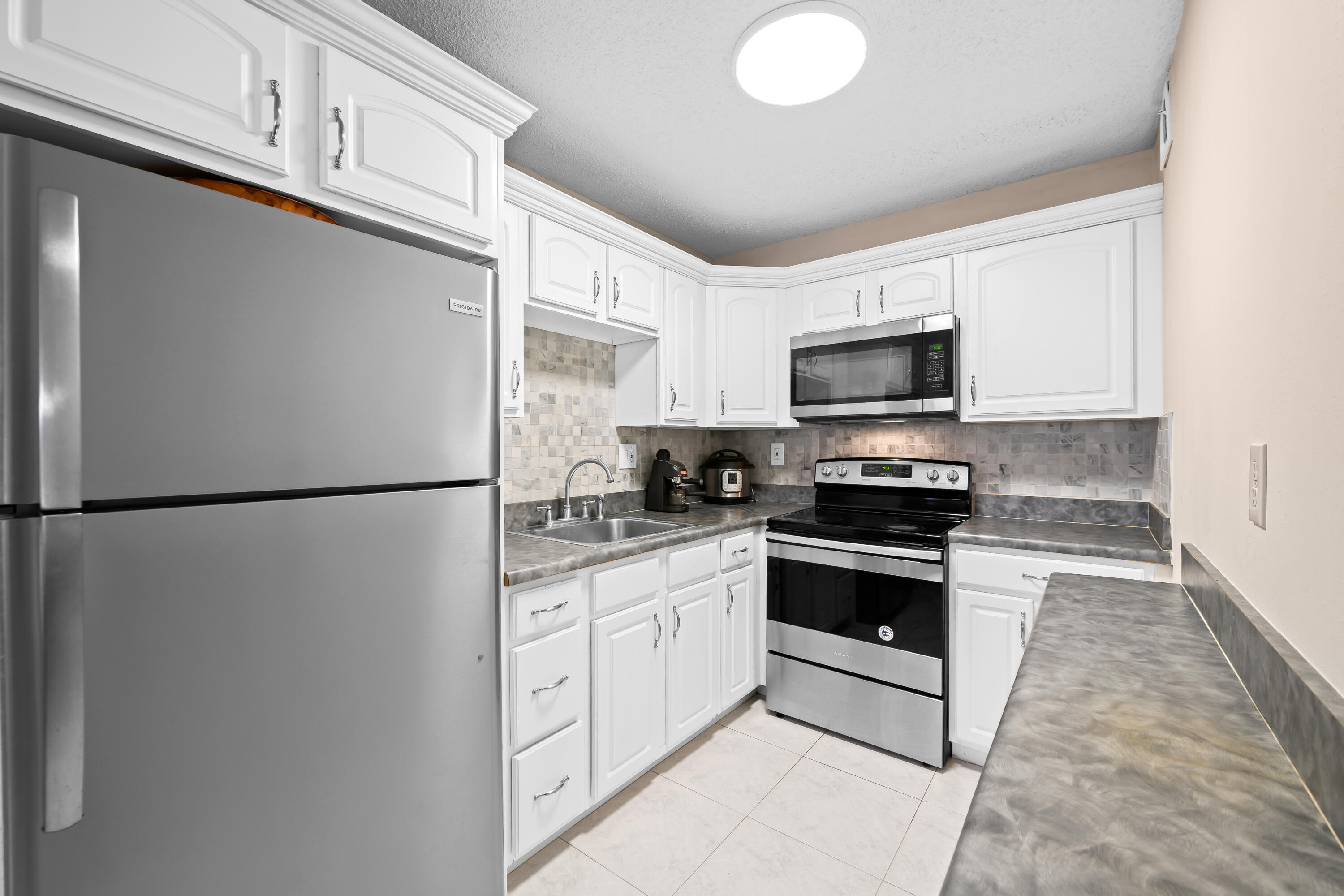 Bright & Airy 2/2 condo located at Sabal Palm Village in Tamarac, 55+ Community. This cozy unit is located on the 2nd floor - Features updated large white kitchen with SS appliances, NEW vinyl flooring throughout & NEW Roof! Large master bedroom with walk-in closet and combo tub/shower. Guest bedroom has mirrored closet - Being used as an office. Spacious screened patio with wroll-ups - Can be used as a Den/ Storage. Laundry room on premises located on same floor, unit comes with extra storage room. The association offers a clubhouse with library, fitness room, heated pool, BBQ area & tennis courts. Secured Lobby. Priced to sell! No minimum income required! Mins to Turnpike, Shopping Plazas & Restaurants. Great Primary or Seasonal residence. Priced to Sell! Schedule your viewing today!