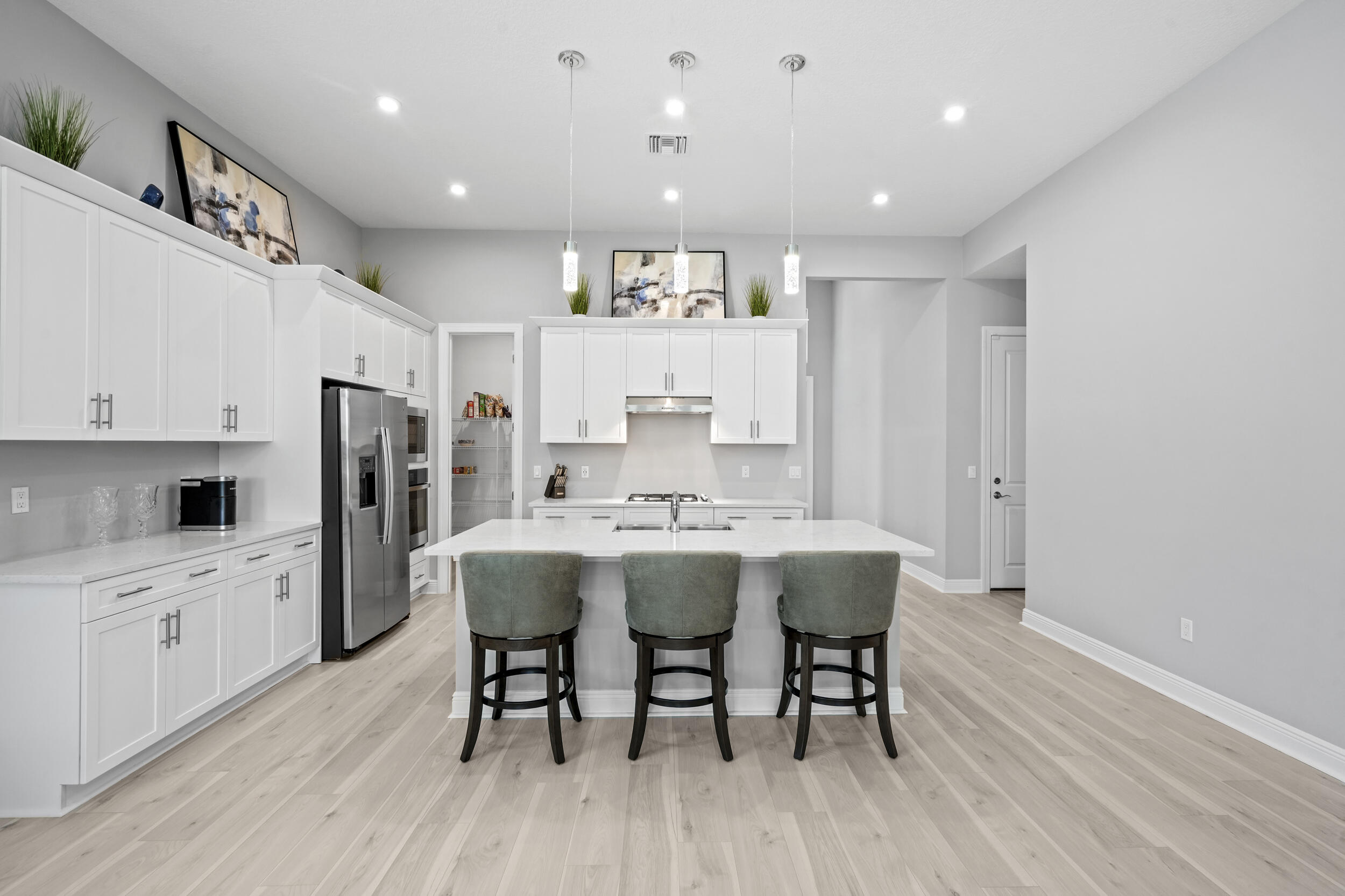 Beautifully designed and meticulously maintained, this stunning Kimberly Model by Kolter Homes offers style, comfort, and convenience. The remarkable 11.5-foot ceilings, abundant natural light, and luxury laminate flooring create a bright, open feel. The chef-inspired kitchen features quartz countertops and ample space for entertaining, while the versatile flex room can serve as a home office or optional fourth bedroom. Enjoy Florida living with a summer kitchen hookup along with impact windows and doors for added peace of mind. Ideally located near Martin and St. Lucie county lines, you're only minutes from major highways, shopping, dining, and top-rated schools.
