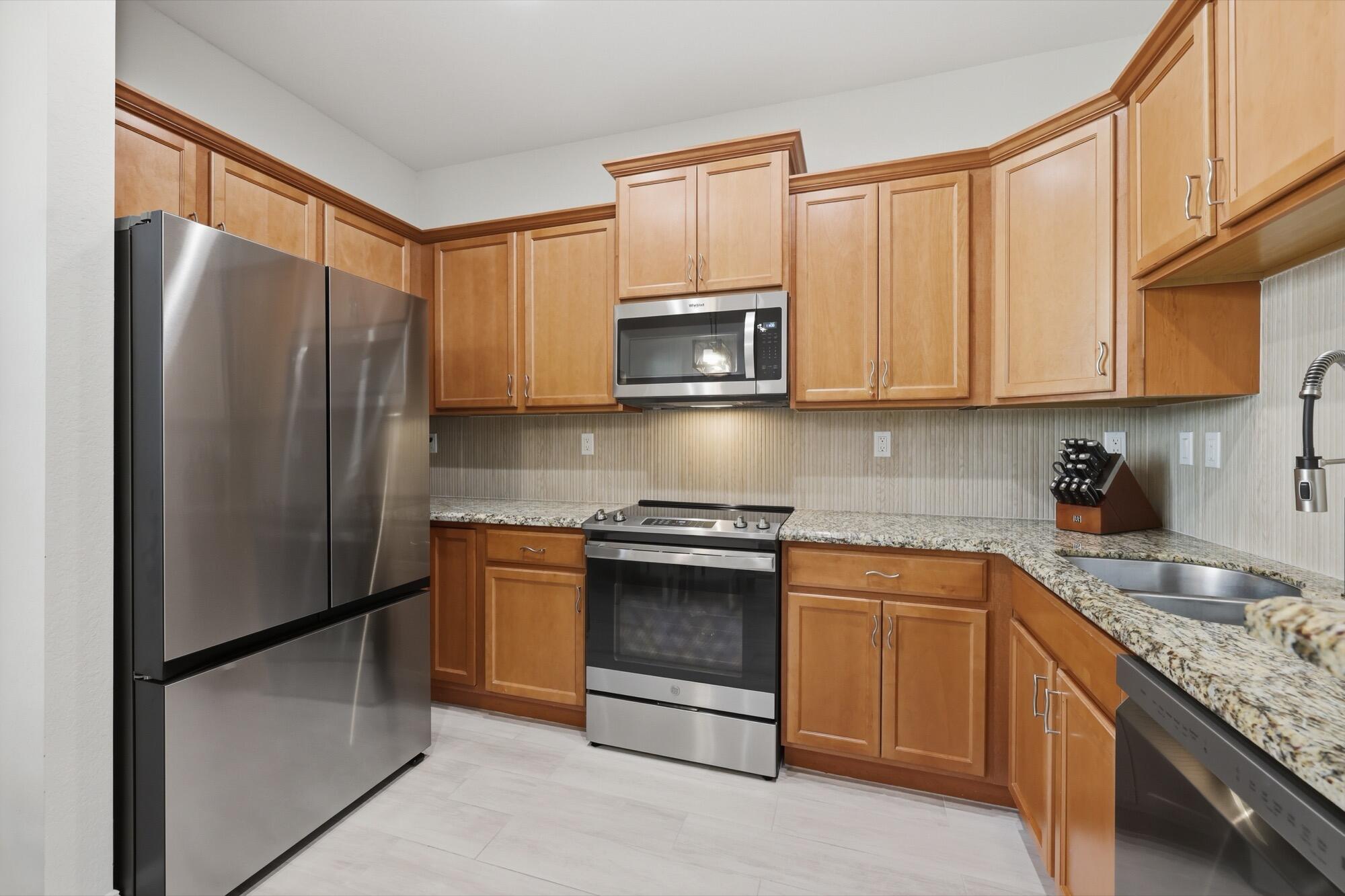 Stunning updated 3 Bed/2.5 Bath townhouse in Pompano Beach featuring brand-new tile floors throughout both levels, impact windows & doors, and 1-car garage. The modern kitchen boasts granite countertops, stylish backsplash, and all-new stainless steel appliances. Open living and dining areas are freshly painted with new lighting and fixtures throughout.The oversized primary suite features a fully remodeled ensuite bath with dual-sink vanity, frameless glass shower, and marble-look tile with matte black fixtures. Custom built-in closet system in the walk-in closet. Two additional bedrooms, and convenient upstairs laundry complete the upper level. Community amenities include pool, fitness center, clubhouse & walking paths around the lake. Minutes to dining, shopping, parks & the beach.       Low HOA fee includes roof repairs, exterior maintenance, landscaping, security patrol, reserve funding, cable & internet and ADT security alarm — making ownership truly hassle-free! Community allows leasing from day one with up to 2 leases per year, making this an excellent investment opportunity as well!