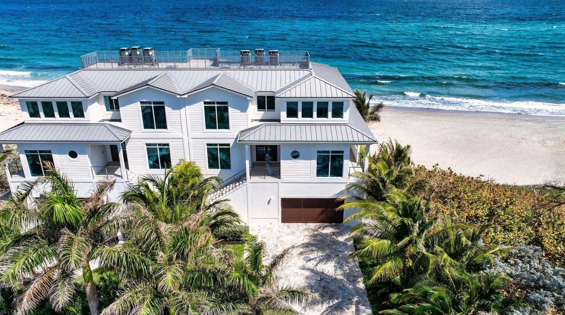 Ocean Ridge townhome, perched directly on the sand, showcases a sunny deck and an expansive wraparound balcony perfect for catching the sunrise. Designed with a sophisticated beach-chic flair, every room frames sweeping views of golden coastline and shimmering aquamarine waters. The main level boasts a light-filled open-concept living space. Downstairs rooms make ideal guest retreats, while the top-level primary suite, with its panoramic oceanfront perch, sits in the sunny southeast corner. 5001 Old Ocean Boulevard, Ocean Ridge, Florida. A hidden jewel along the Gold Coast. Known for its serene charm, Ocean Ridge is treasured for its tranquil vibe and untouched natural beauty, nestled between the Atlantic and the Intracoastal Waterway.

PROPERTY:
Tucked behind tropical landscaping, a gate, and a 40-foot-deep seawall, this direct oceanfront townhome invites an alfresco lifestyle. Residents enjoy sunny days on the sundeck or lounging on the wraparound balconies that gaze out over endless sandy shoreline and the sparkling sea.

RESIDENCE:
This three-level, four-bedroom residence captures the essence of beachfront luxury with 7,148± square feet of sleek, modern elegance. Built new in 2018, it's engineered with high-impact windows and doors and styled for maximum ocean exposure. Every room, even the laundry, basks in views and breezes. On the main floor, grand double doors lead into an open living/dining/kitchen space, seamlessly extended by sliding glass doors that open to the sunrise-facing terrace. The living room features a lighted shiplap-paneled ceiling and built-in display cabinetry, while the double-island kitchen stuns with high-end appliancesSub-Zero refrigeration, Wolf oven/range, four dishwasher drawers, and a butler's pantry with wine cooler and wet bar. The staircase and elevator, enclosed in glass, glow with natural light. Upstairs, the primary suite opens to a private balcony and includes a spa bath with freestanding soaking tub, glass shower, dual vanities, smart toilet, and ocean-view windows. Another guest suite shares this incredible view. The lower level hosts a casual family room with a kitchenette, two guest suites, and spectacular seaside views. Additional features include an office, powder room, laundry room, and three-car garage. Porcelain tile floors flow throughout, and modern comforts include Sonos sound, motorized blinds, sprinkler system, and zoned A/C with floor-by-floor thermostats.

DISCLAIMER: Information published or otherwise provided by the listing company and its representatives including but not limited to prices, measurements, square footages, lot sizes, calculations, statistics, and videos are deemed reliable but are not guaranteed and are subject to errors, omissions or changes without notice. All such information should be independently verified by any prospective purchaser or seller. Parties should perform their own due diligence to verify such information prior to a sale or listing. Listing company expressly disclaims any warranty or representation regarding such information. Prices published are either list price, sold price, and/or last asking price. The listing company participates in the Multiple Listing Service and IDX. The properties published as listed and sold are not necessarily exclusive to listing company and may be listed or have sold with other members of the Multiple Listing Service. Transactions where listing company represented both buyers and sellers are calculated as two sales. "No payments made until title passes" Some affiliations may not be applicable to certain geographic areas. If your property is currently listed with another broker, please disregard any solicitation for services. Information published or otherwise provided by seller, listing company or its representatives is deemed reliable but are not guaranteed and subject to errors, omissions, or changes without notice. Copyright 2025 by the listing company. All Rights Reserved.