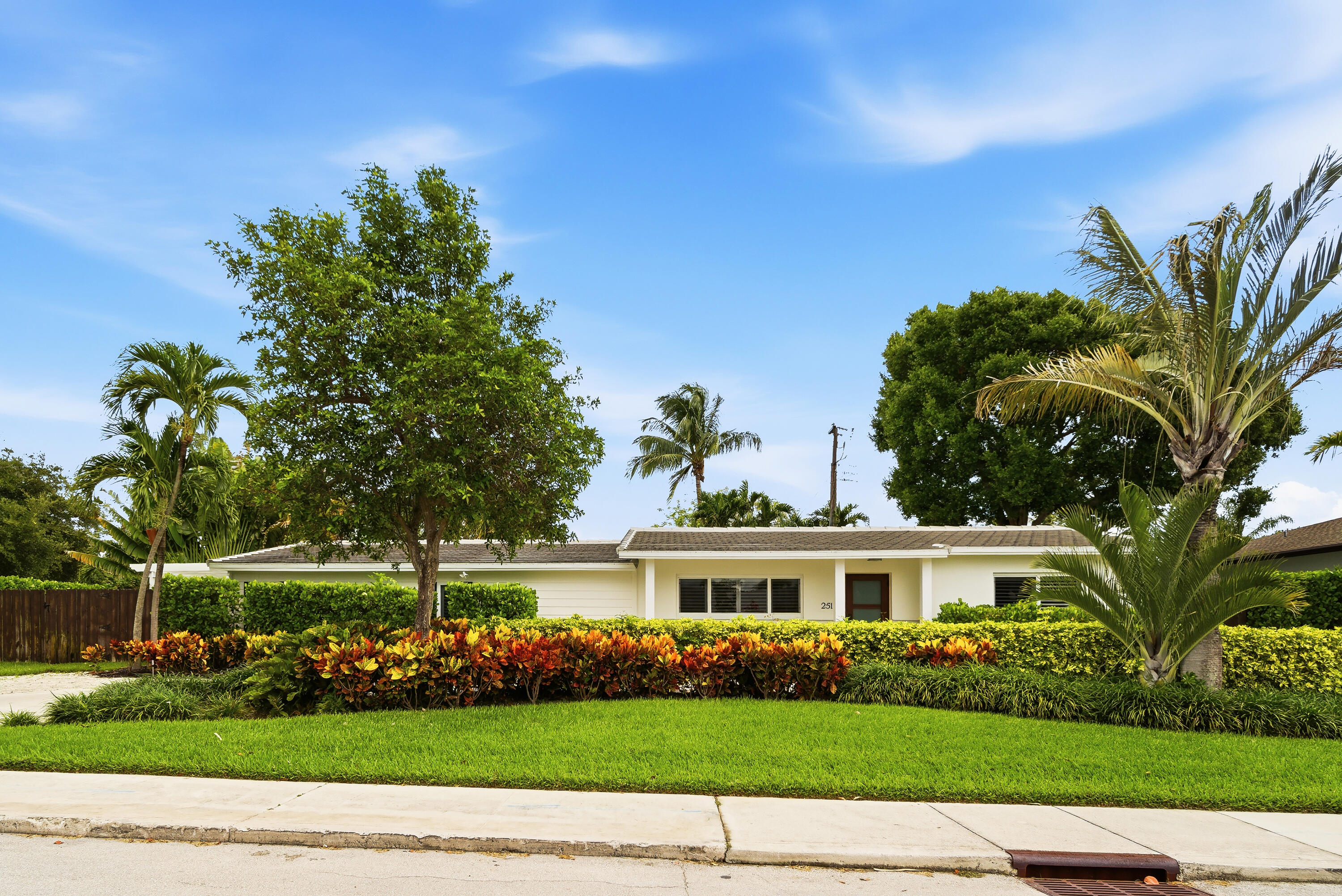 This charming, well-proportioned ranch home sits on a lushly landscaped 11,899 square foot lot in the coveted SoSo neighborhood of West Palm Beach. The Primary Bedroom is a serene retreat, ample in size, with  loads of natural light, two large walk-in closets and a private bouganvilla-covered pergola outside the French doors. The Primary Bath features a double sink vanity, freestanding tub, oversized walk-in shower, separate water closet, and sizable linen closet. The two guest rooms and shared bath are on the opposite side of the house, quiet and tucked away from the main living areas. The recently updated kitchen features a new smart gas range and smart dishwasher. There is a screened in porch just off the dining room, with another dining area outside on the brushed marble pavers.  The heated saltwater pool and spa are wifi enabled and operable from your phone, as is the upgraded sprinkler system and outdoor lighting. New AC in 2024 with dehumidifier in the attic. EV charger. Outdoor Sonos speakers. Roof is 2021. Neighborhood highlights include The Park golf course, the new Trader Joe's, the beloved Aioli, Don Vittorio's for fresh fruit and veg, and Family Produce for wholesale orchids and fresh flowers.